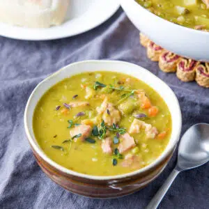Square photo of pea soup with fresh thyme in it - square