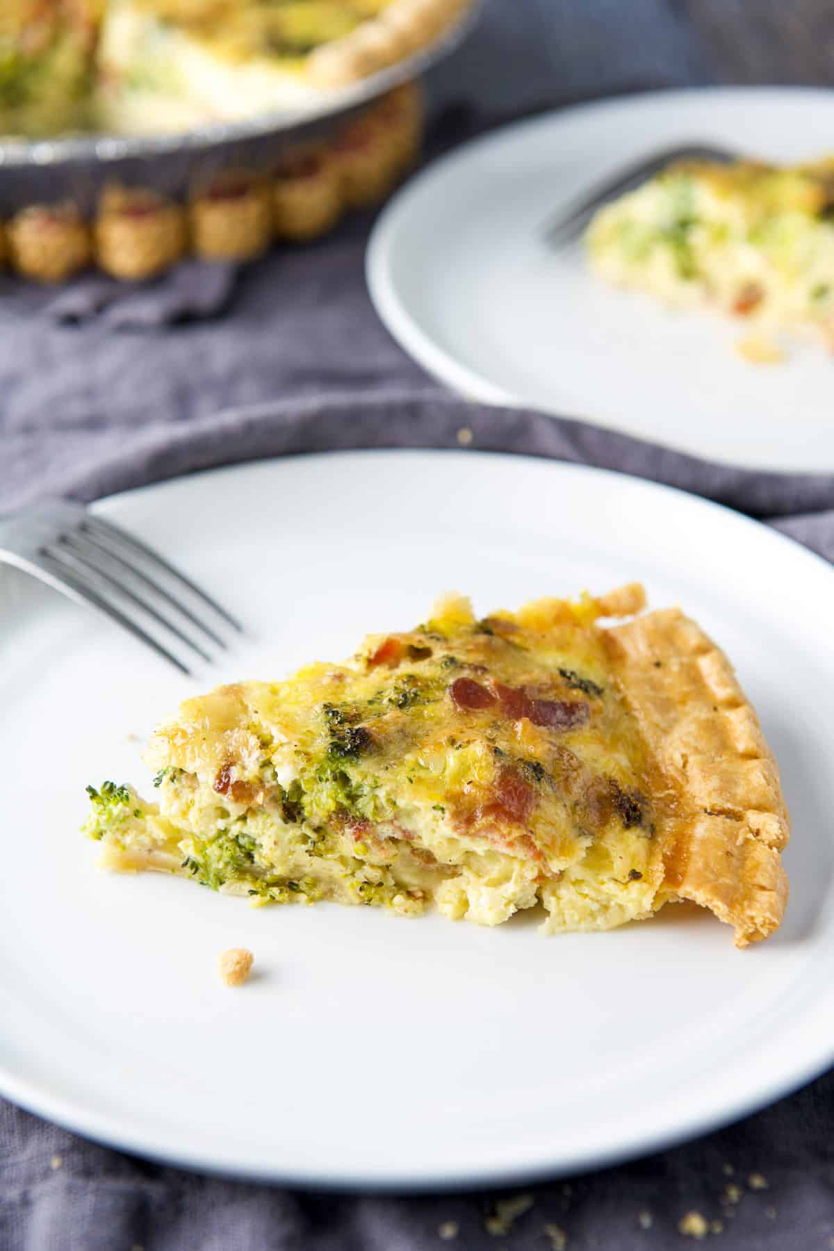 Close view of the quiche on a white plate with a fork