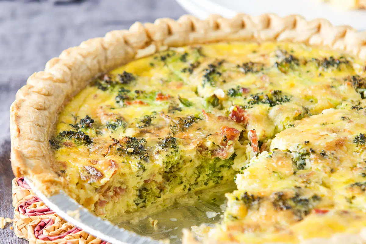Quiche in a pie plate with a piece taken out - horizontal