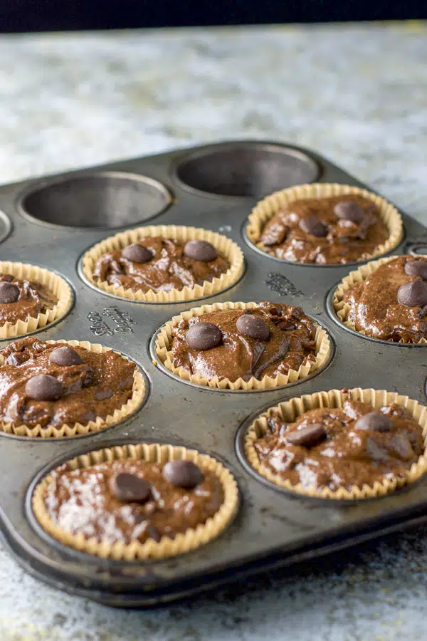 Nine muffin cups filled with the chocolate muffin batter