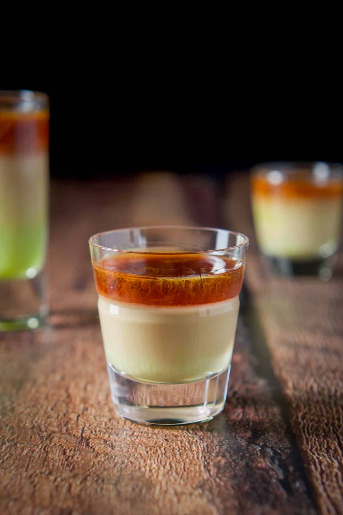 Beveled glass with the green, tan and brown layered shot in front of the two other glasses