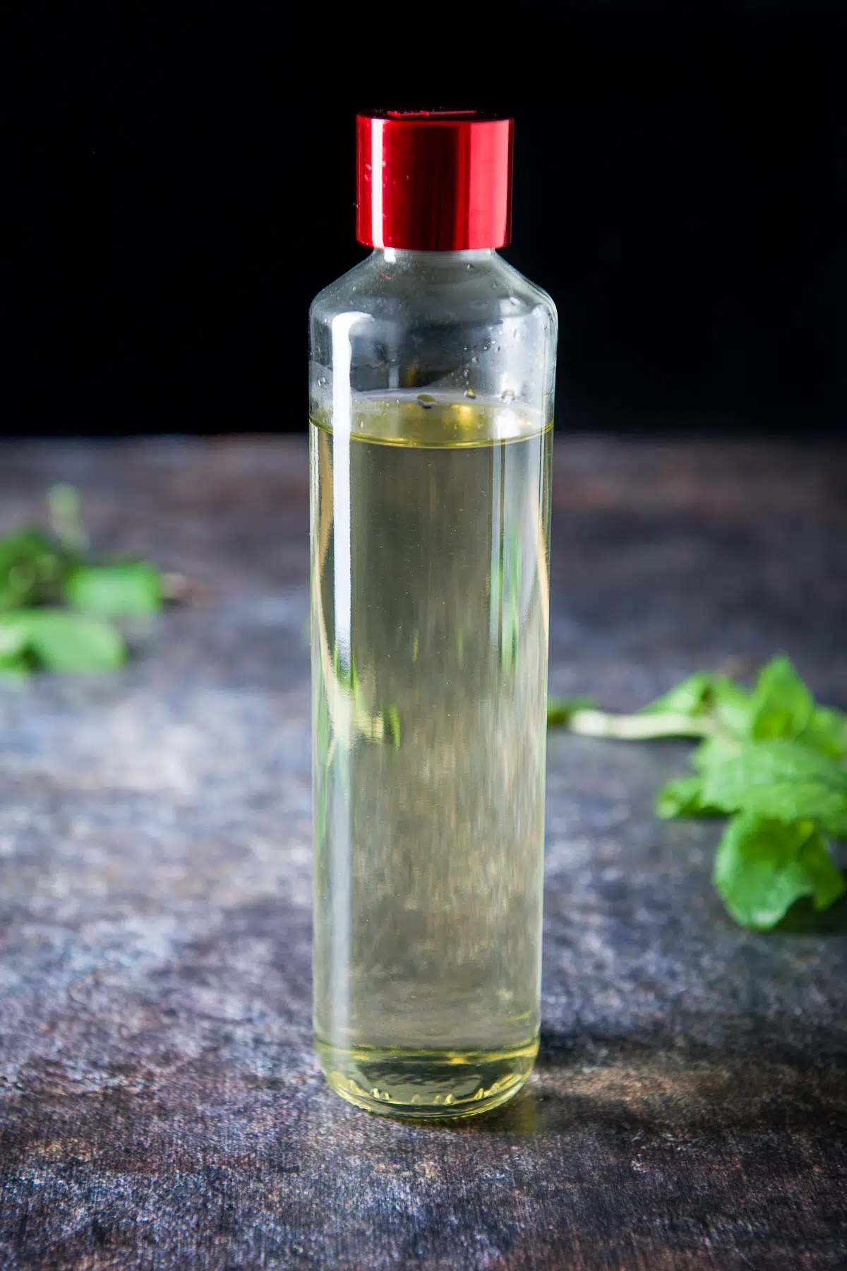 A glass bottle with the cooling syrup with mint on the table