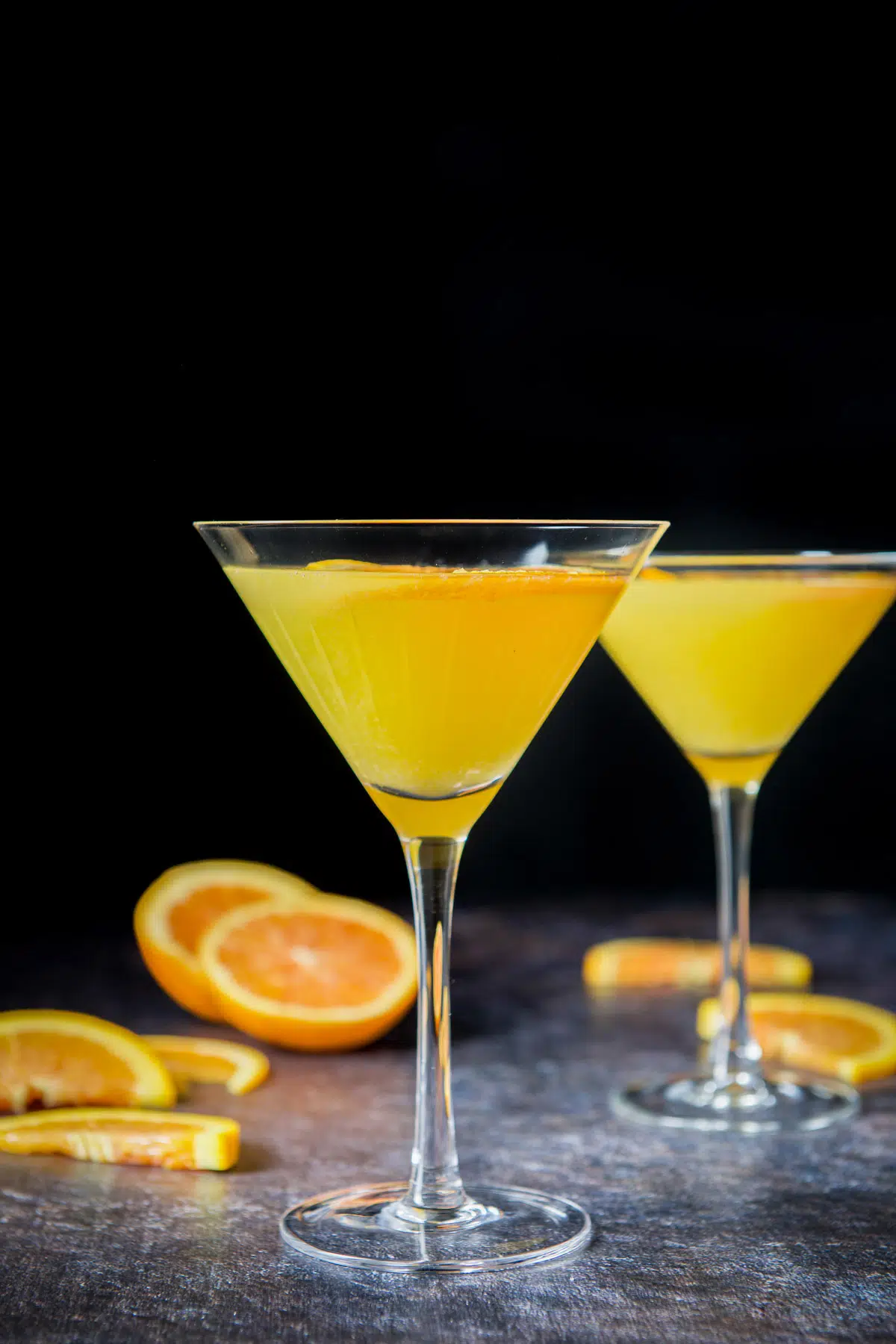 Vertical view of two glasses with the orange martini in it