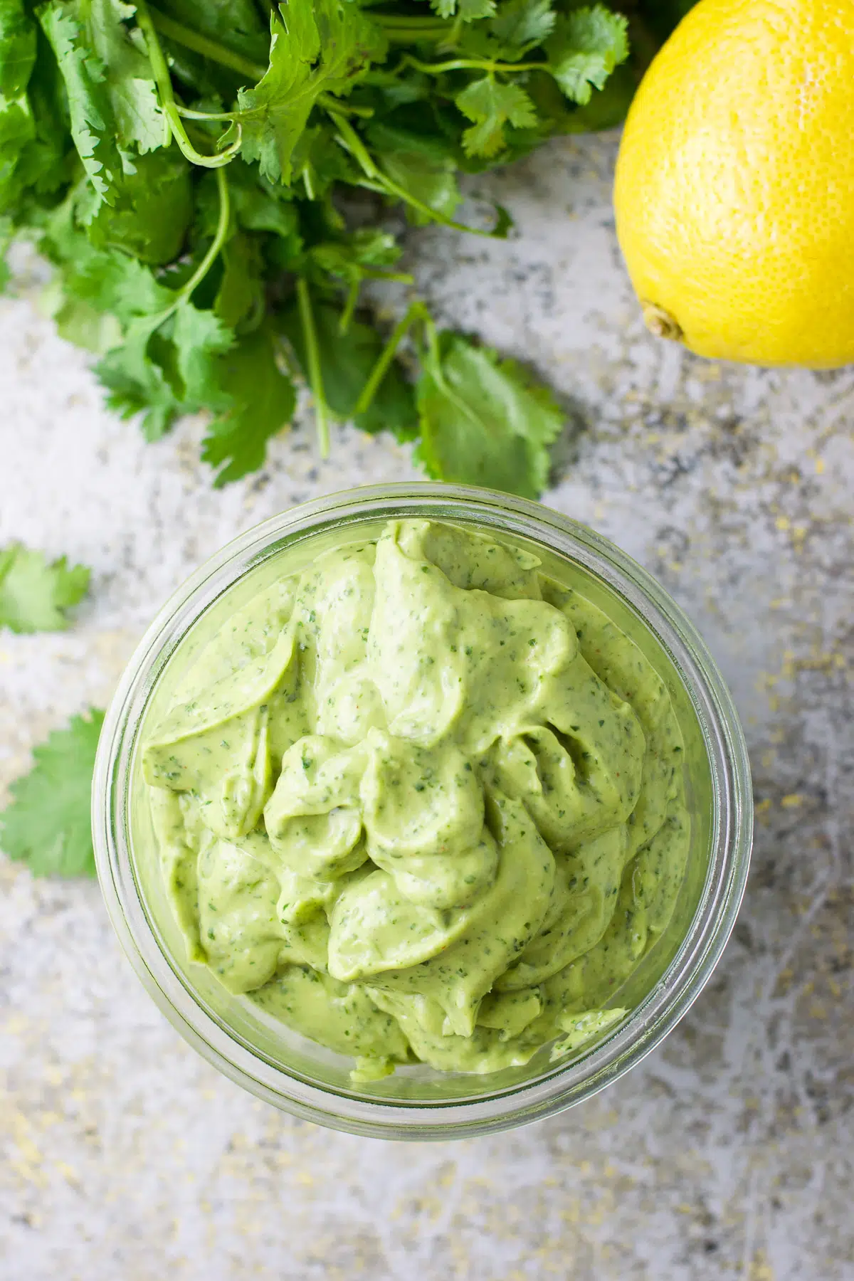 Overhead view of the avocado sauce with lemon and cilantro on the table