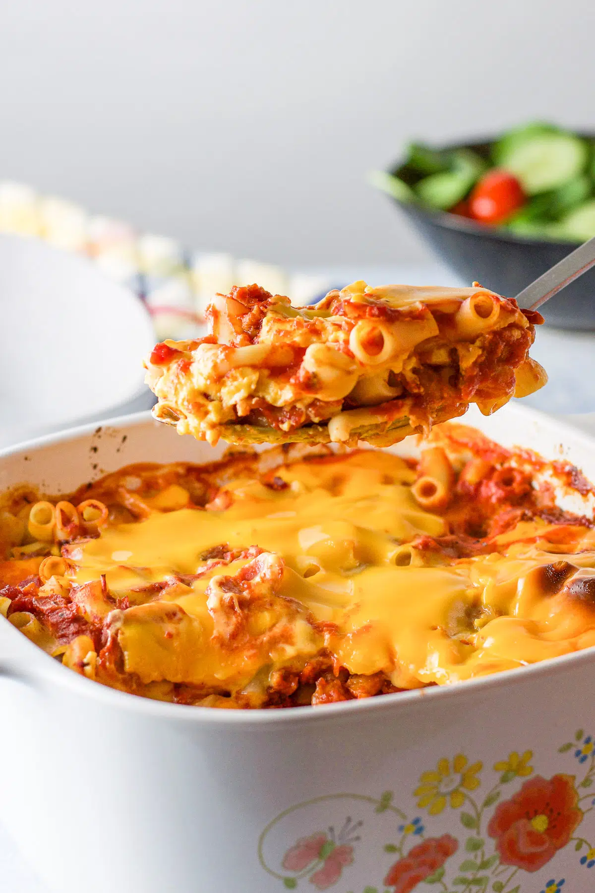 A big spoonful of pasta casserole held over the casserole dish