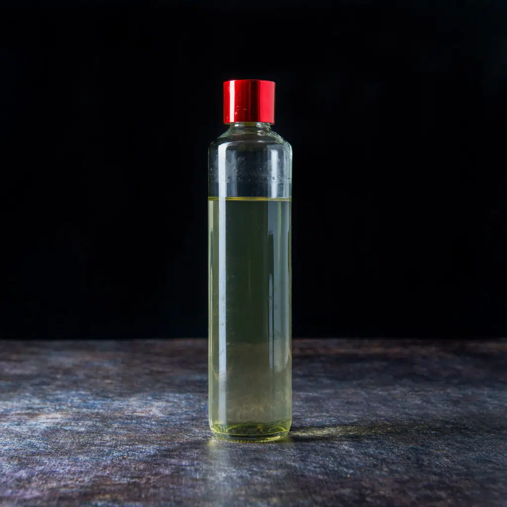 Square photo of a thin bottle filled with mint syrup