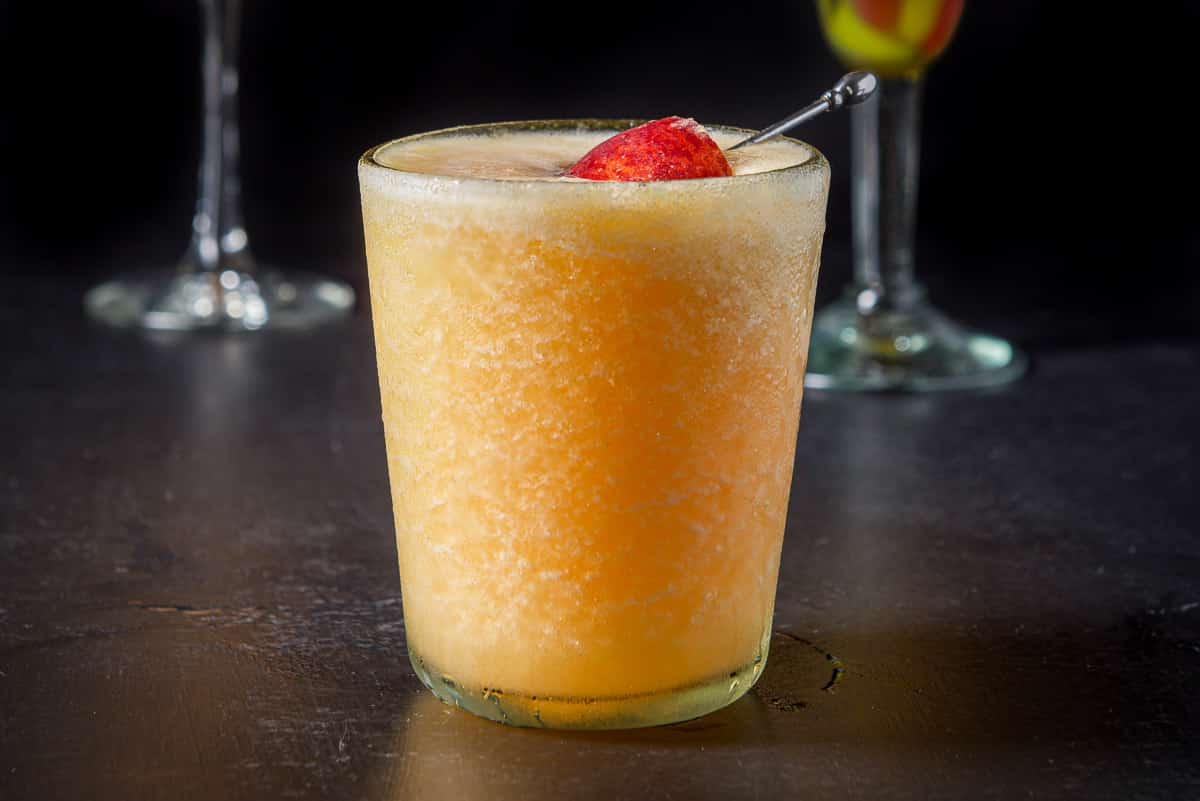 horizontal photo of frozen peach margarita in a glass