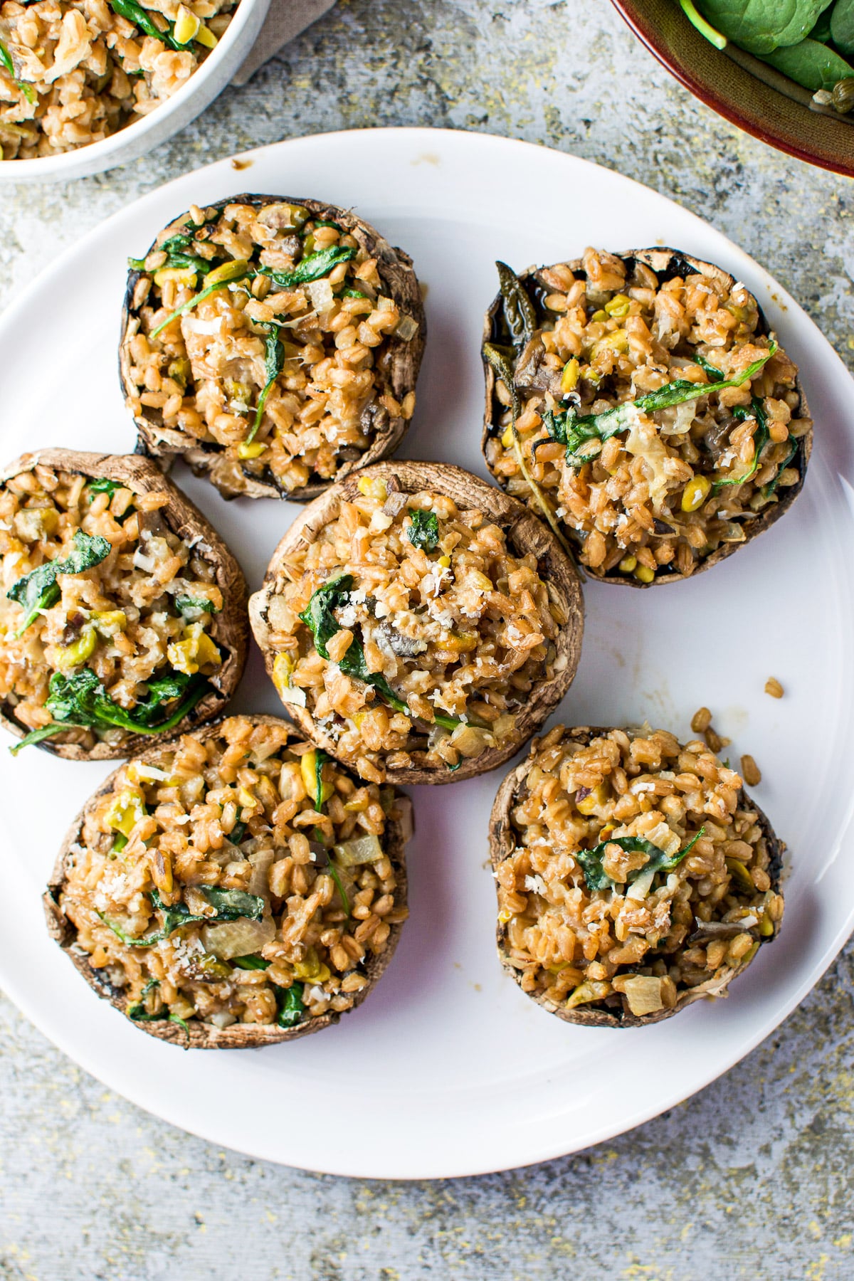 Overhead view of a plate with five stuffed mushrooms on it