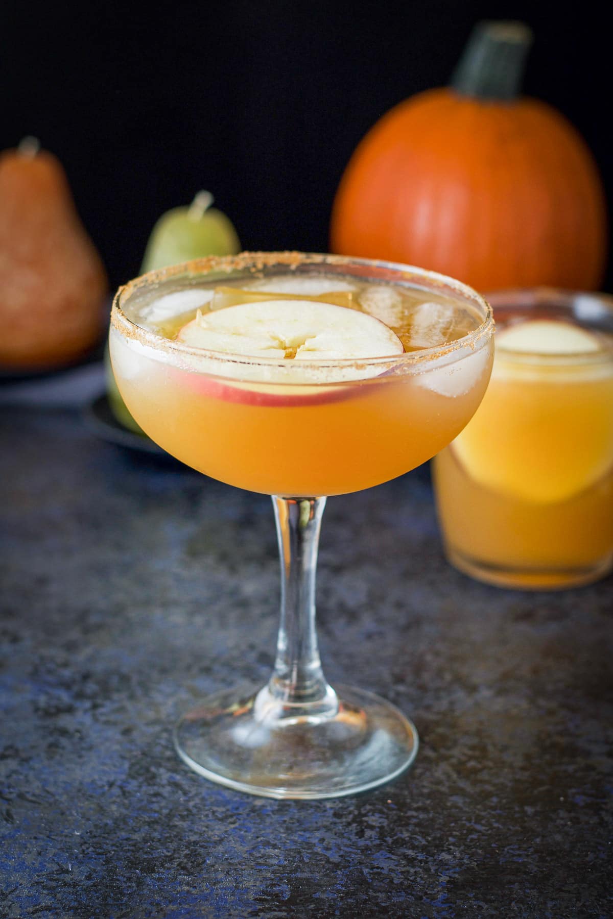 Big bowl margarita glass with the cider margarita and apple slice in it