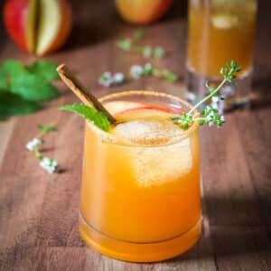 Square photo of a garnished apple cider cocktail in a short glass