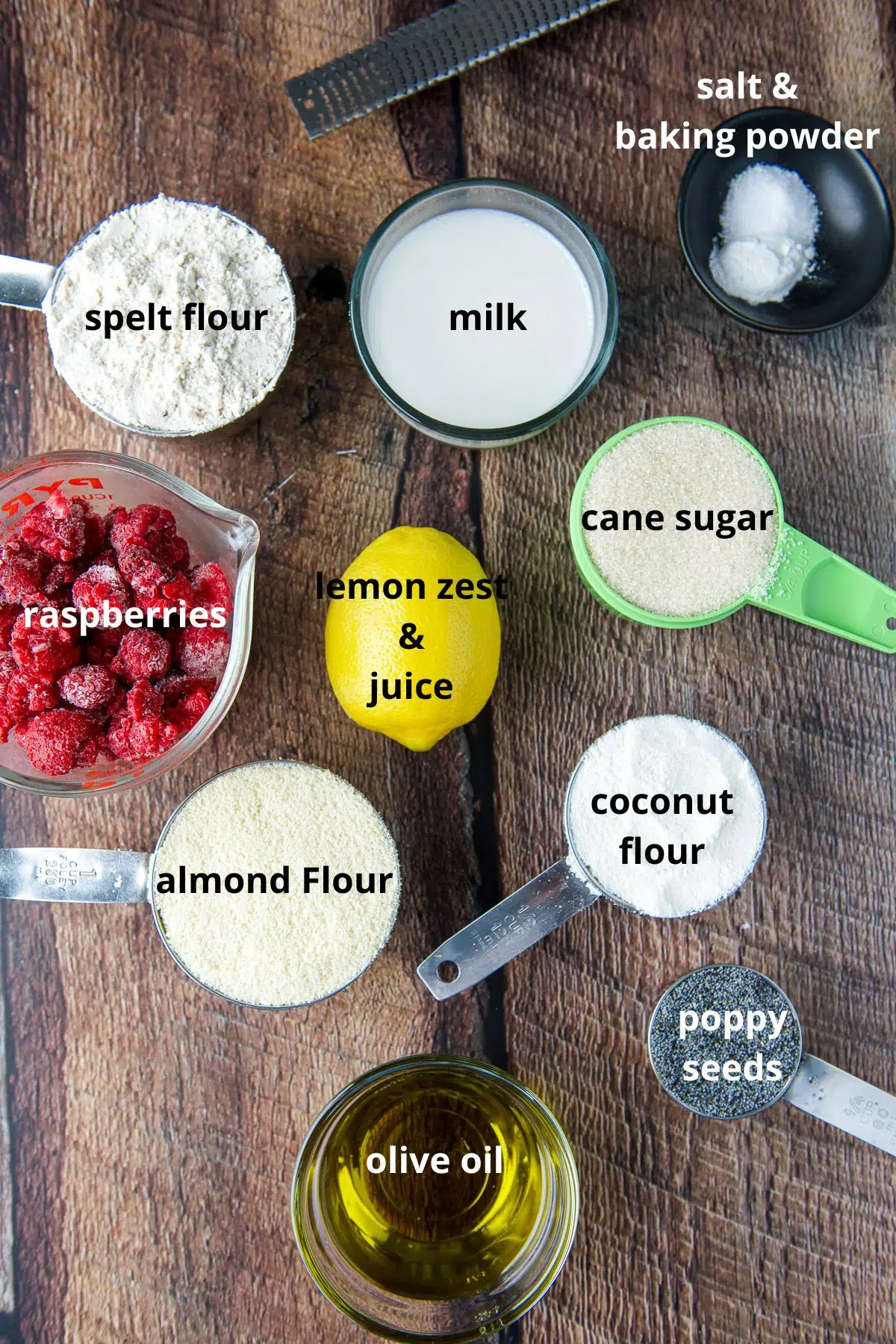 overhead view of ingredients - flours, sugar, poppy seeds, oil, milk, raspberries and baking powder