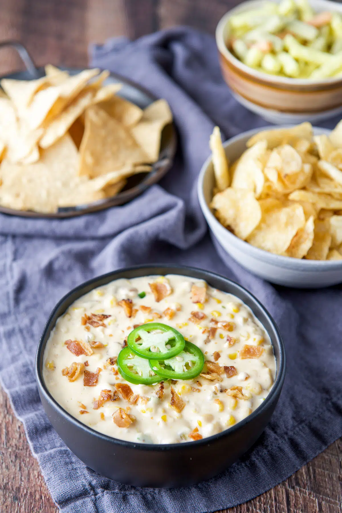 Chips behind a big bowl of creamy corn dip