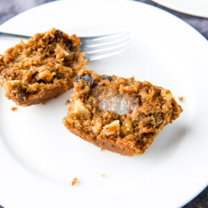 square photo of a muffin slathered with butter on a white plate