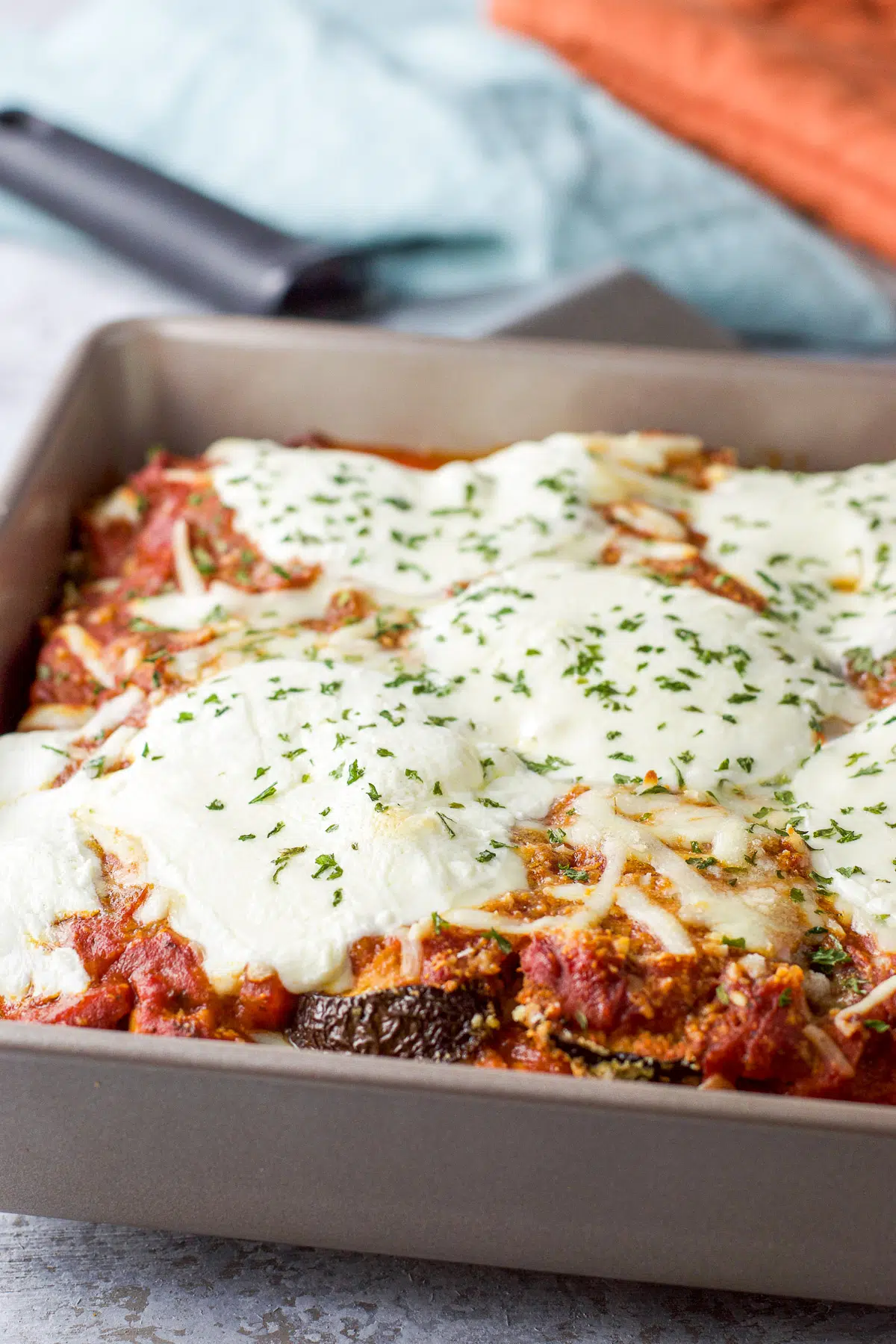 A pan of eggplant parmesan with parsley on top