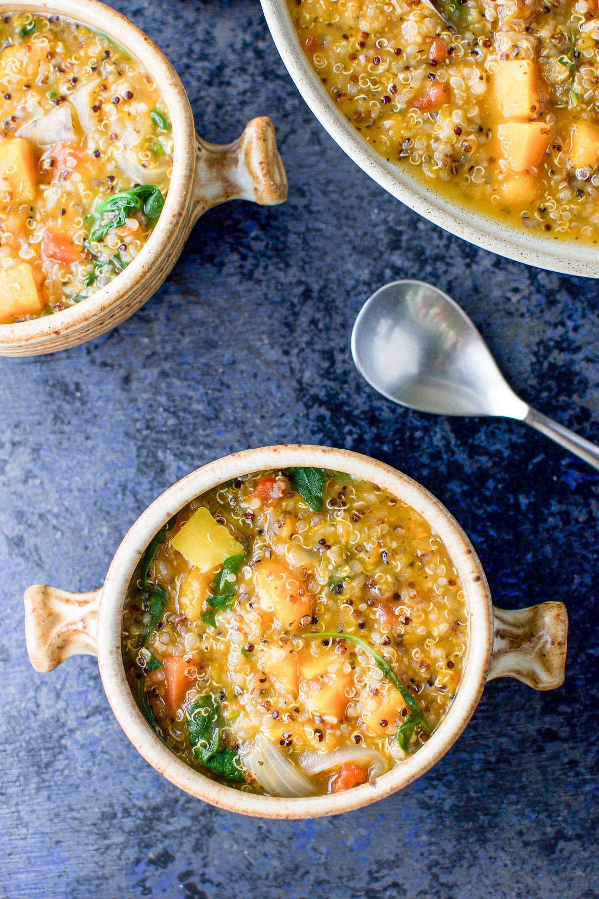 Overhead view of the stew in two crocks and a big serving bowl
