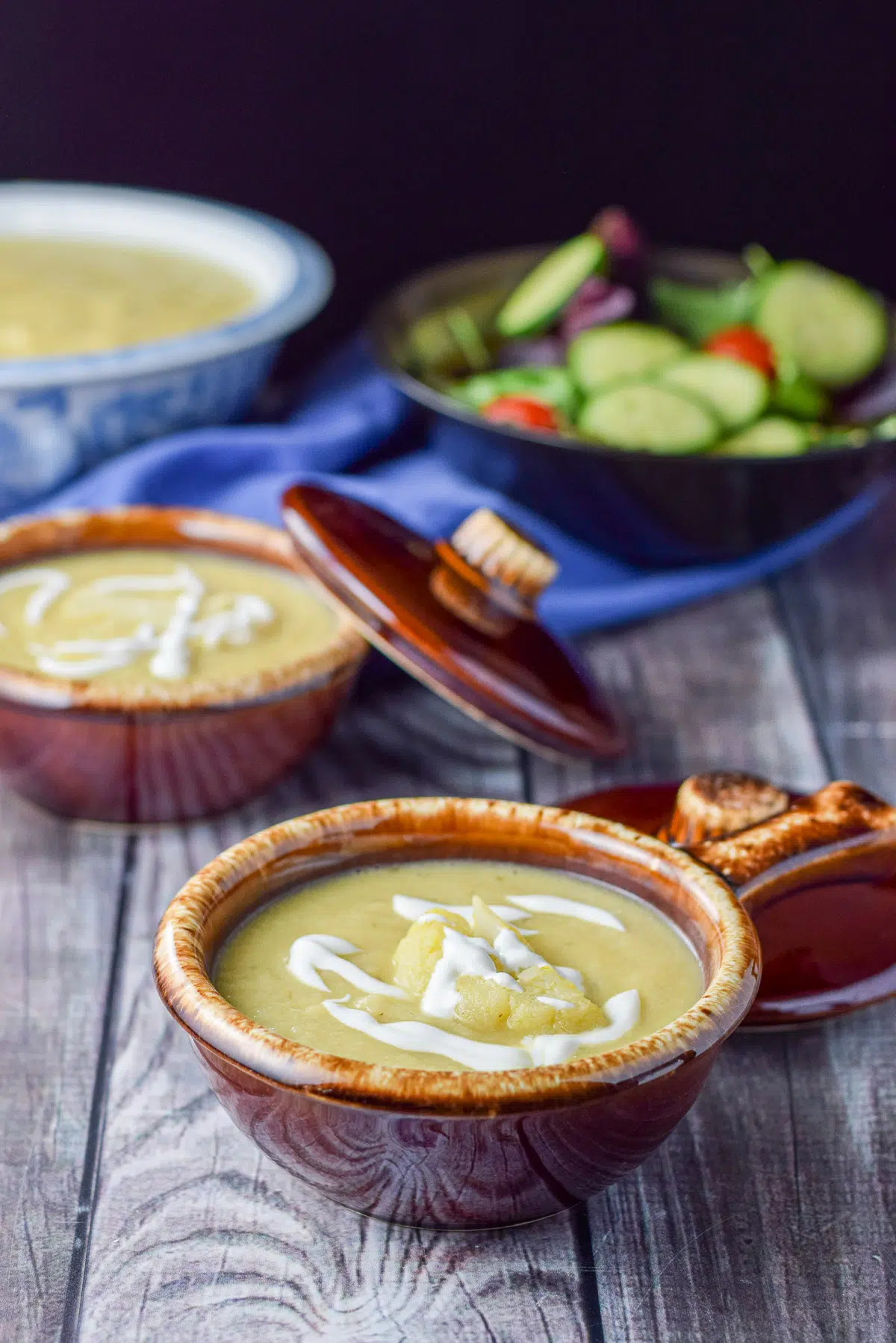 Two crocks with cauliflower soup with sour cream drizzle