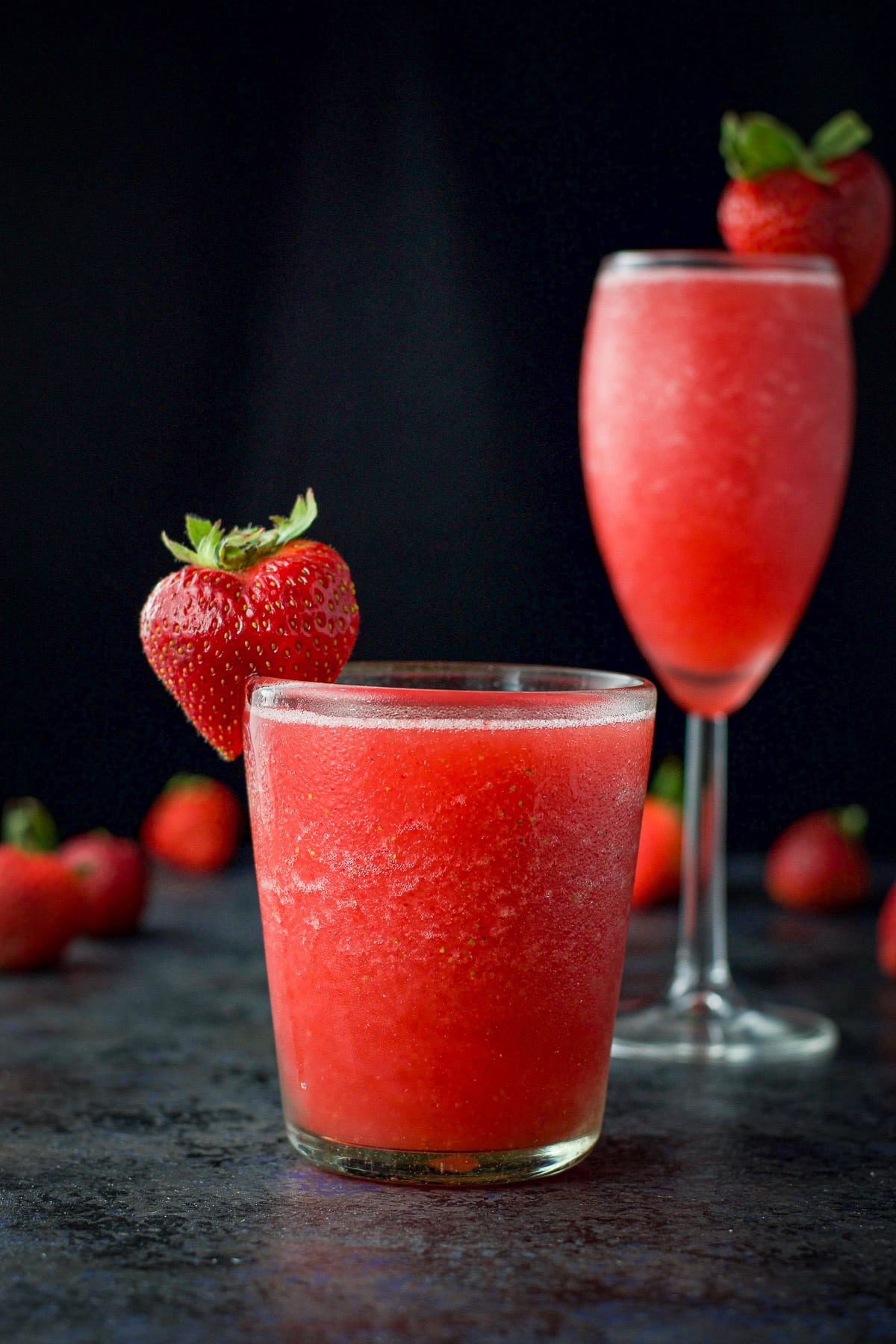 Vertical view of the short glass with the frozen drink with the wine glass in the back