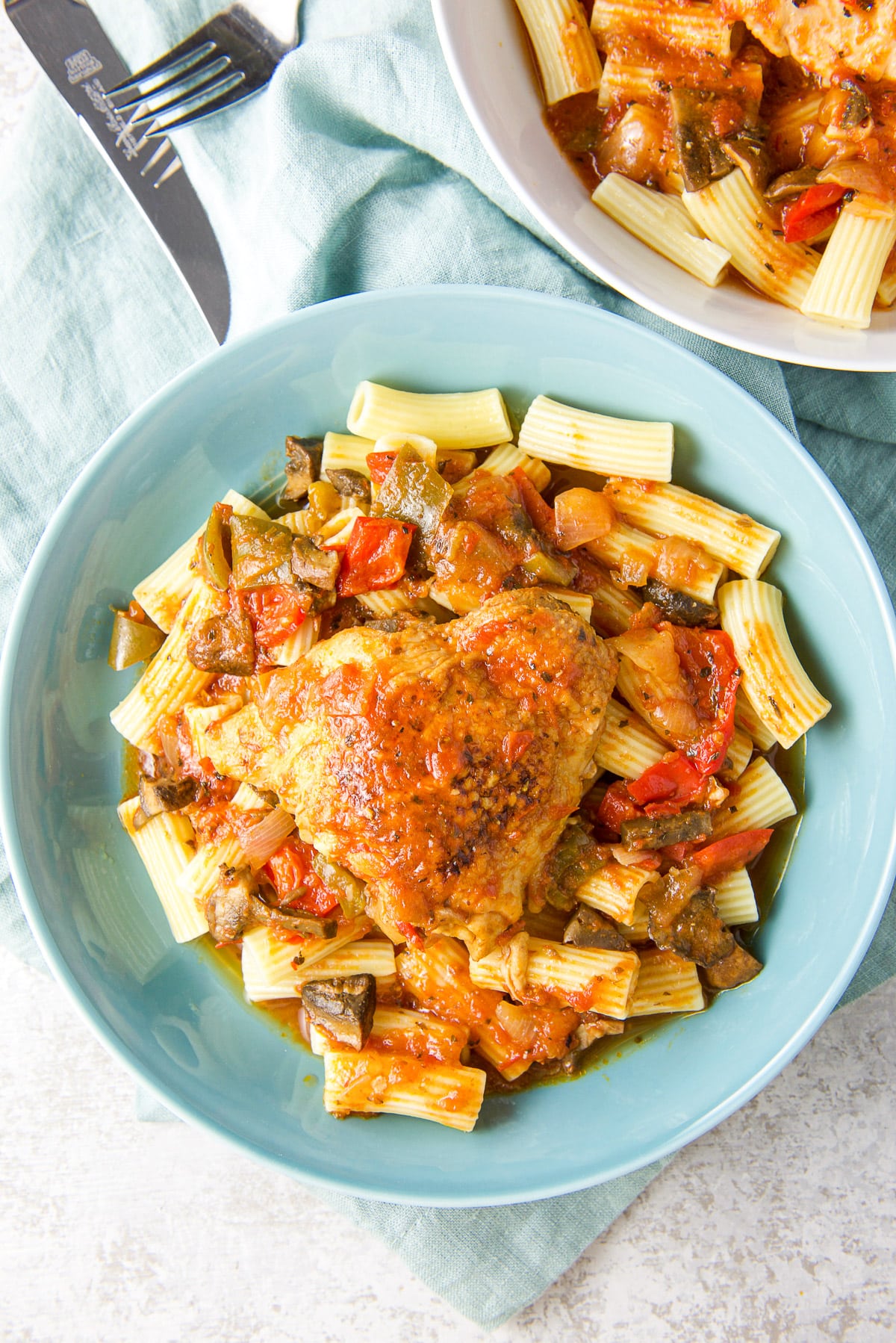 Overhead view of the pasta covered with sauce and chicken thighs