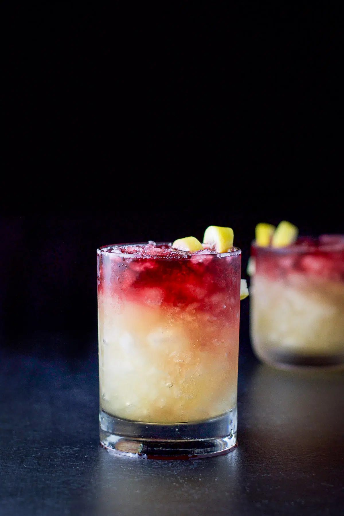 Vertical view of two sour cocktails with wine floating on top