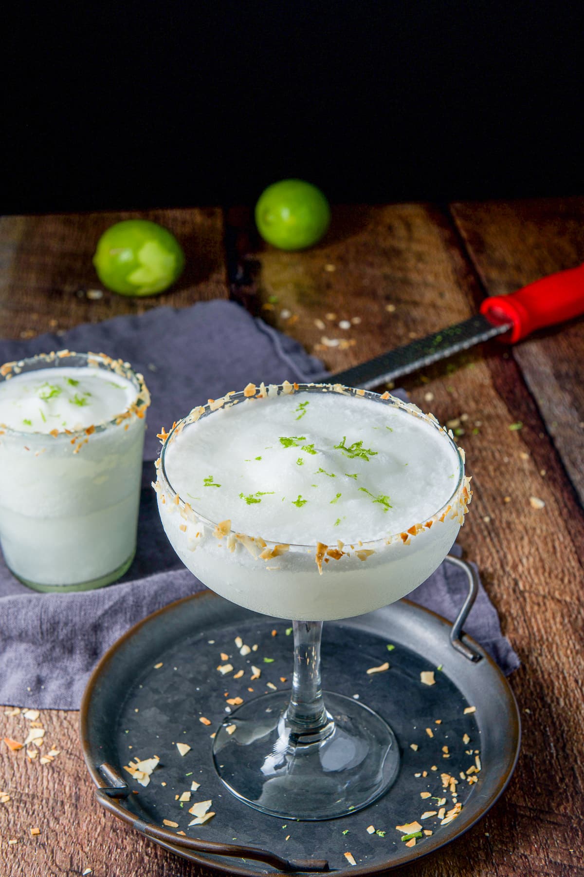 Two margarita glasses filled the white margarita on the table