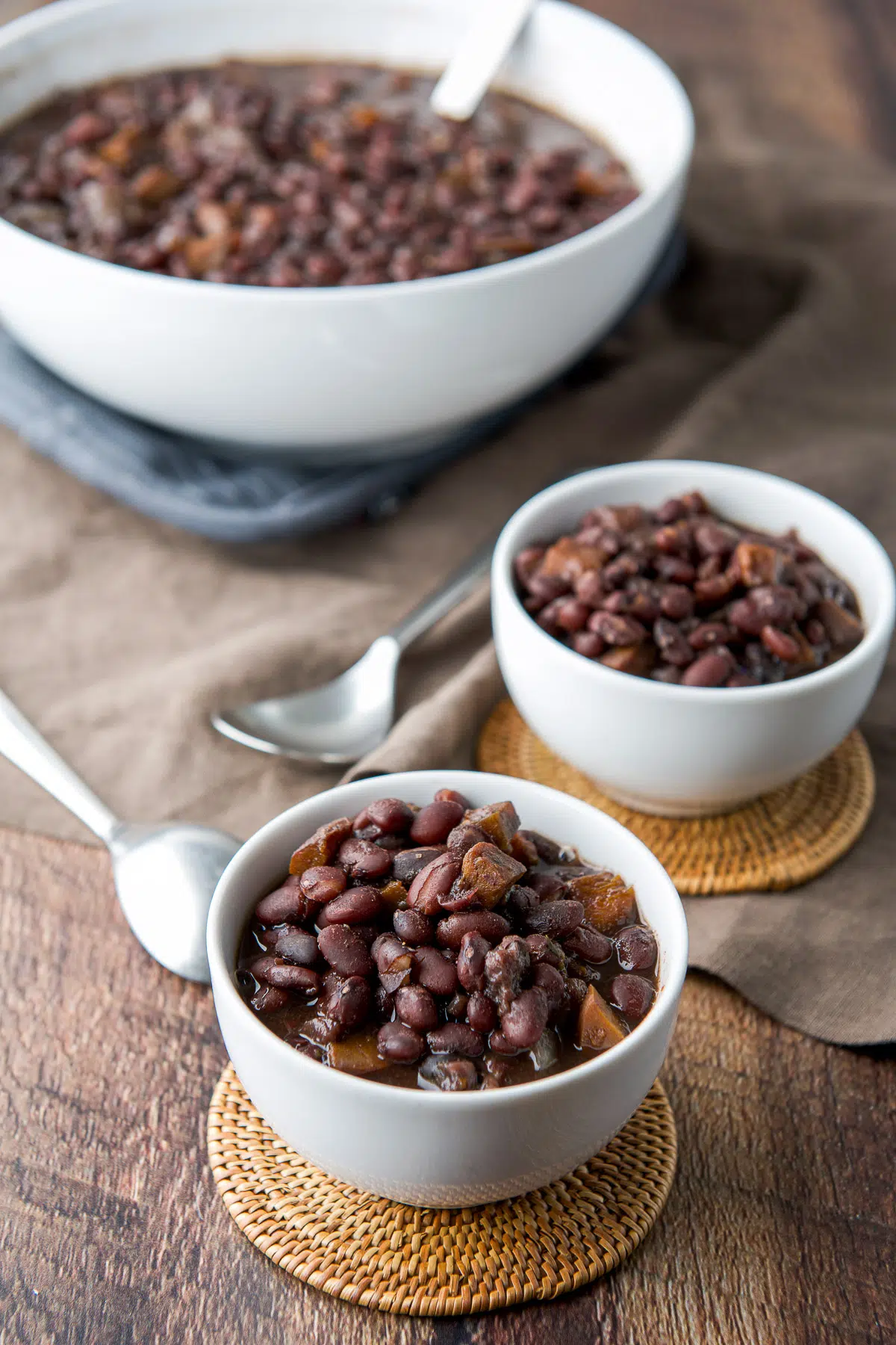 Two small bowls and a serving bowl filled with the beans
