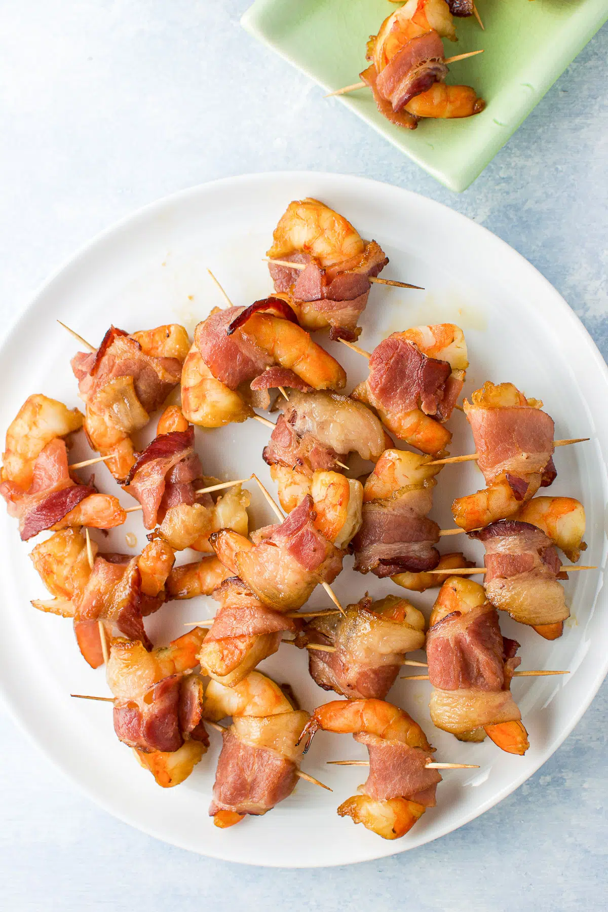 Overhead view of the white plate with bacon wrapped shrimp