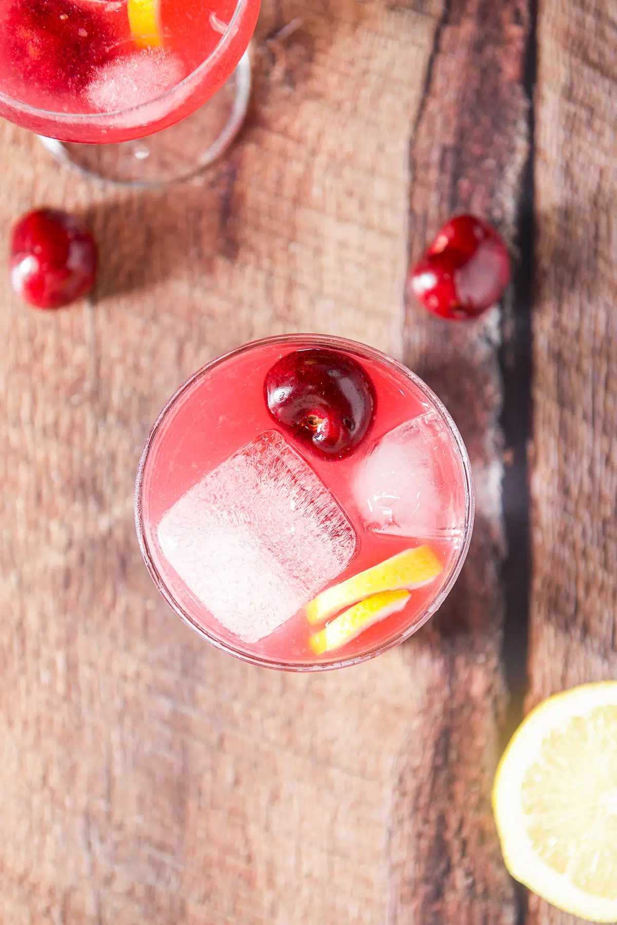 Overhead view of the cherry sour with cherries and lemon twists
