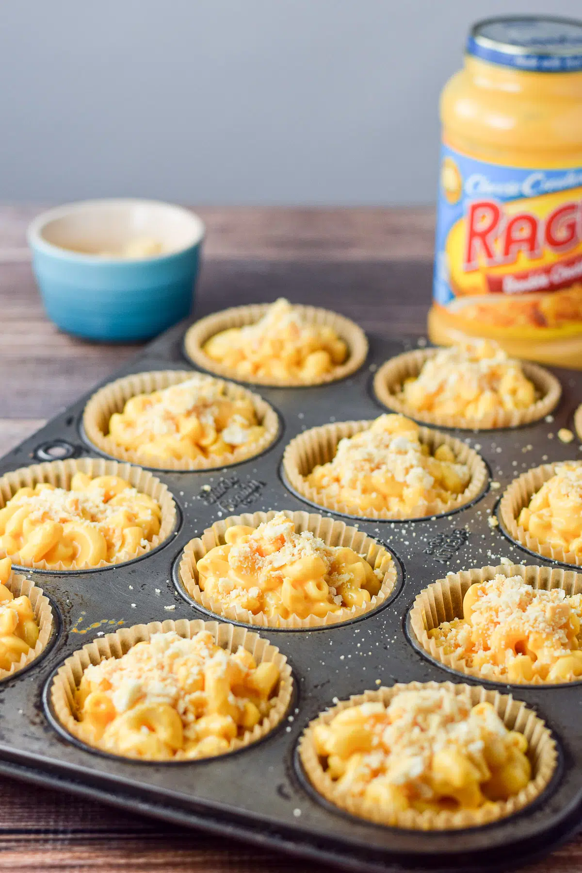 a muffin tin filled with the mac and cheese ready to go in the oven