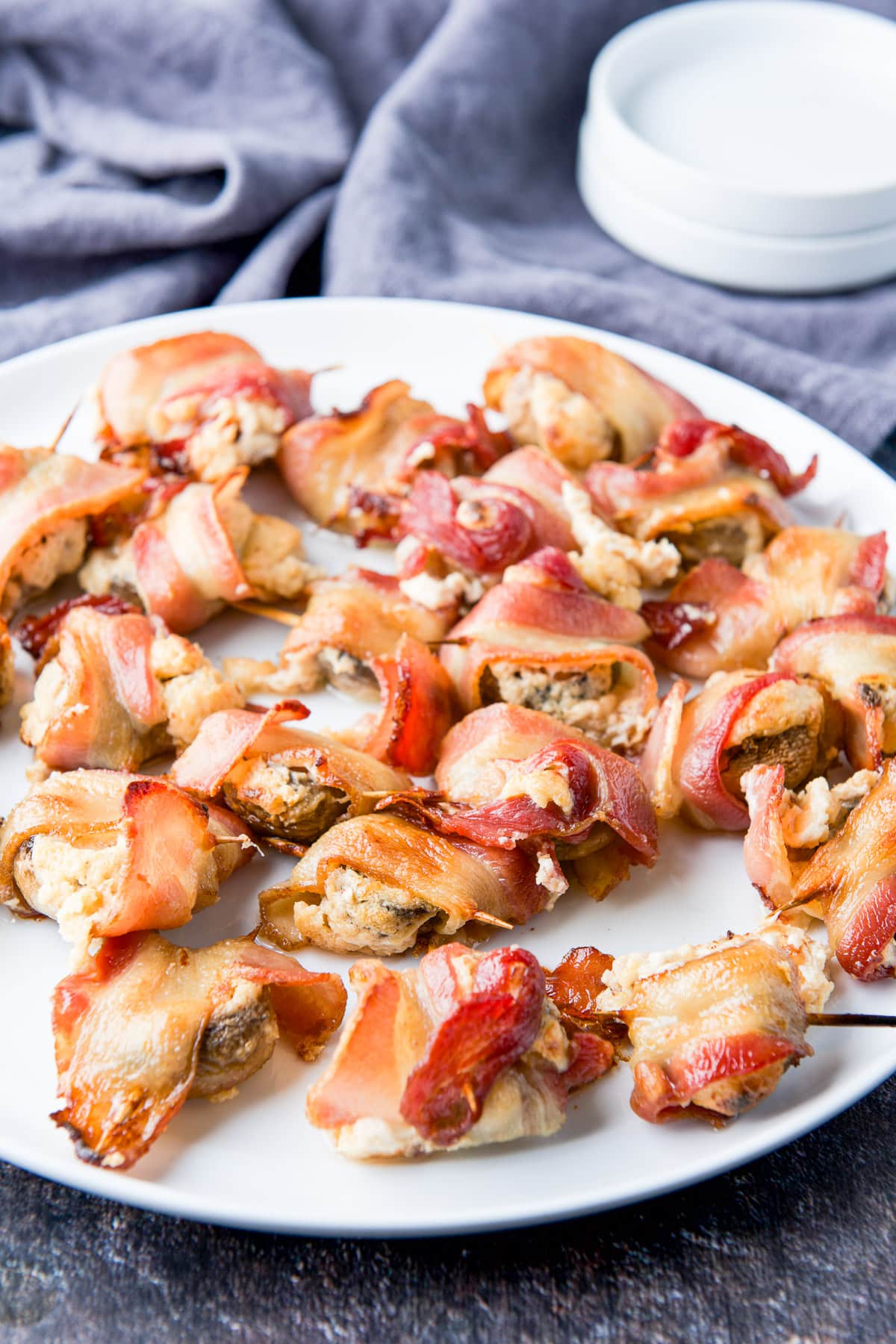 a white plate with the bacon wrapped appetizer on it