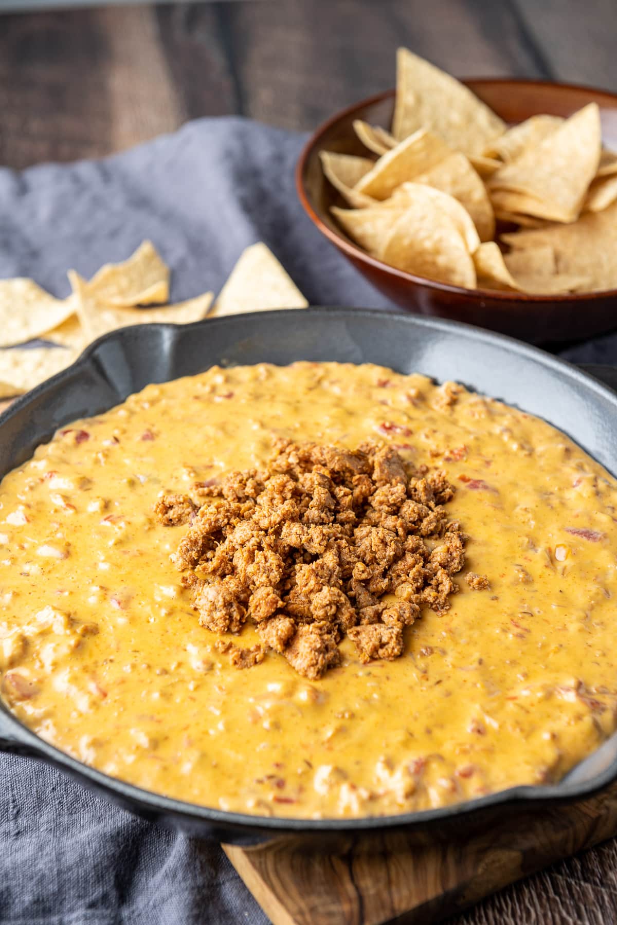 A meat dip in a pan with chips in the back