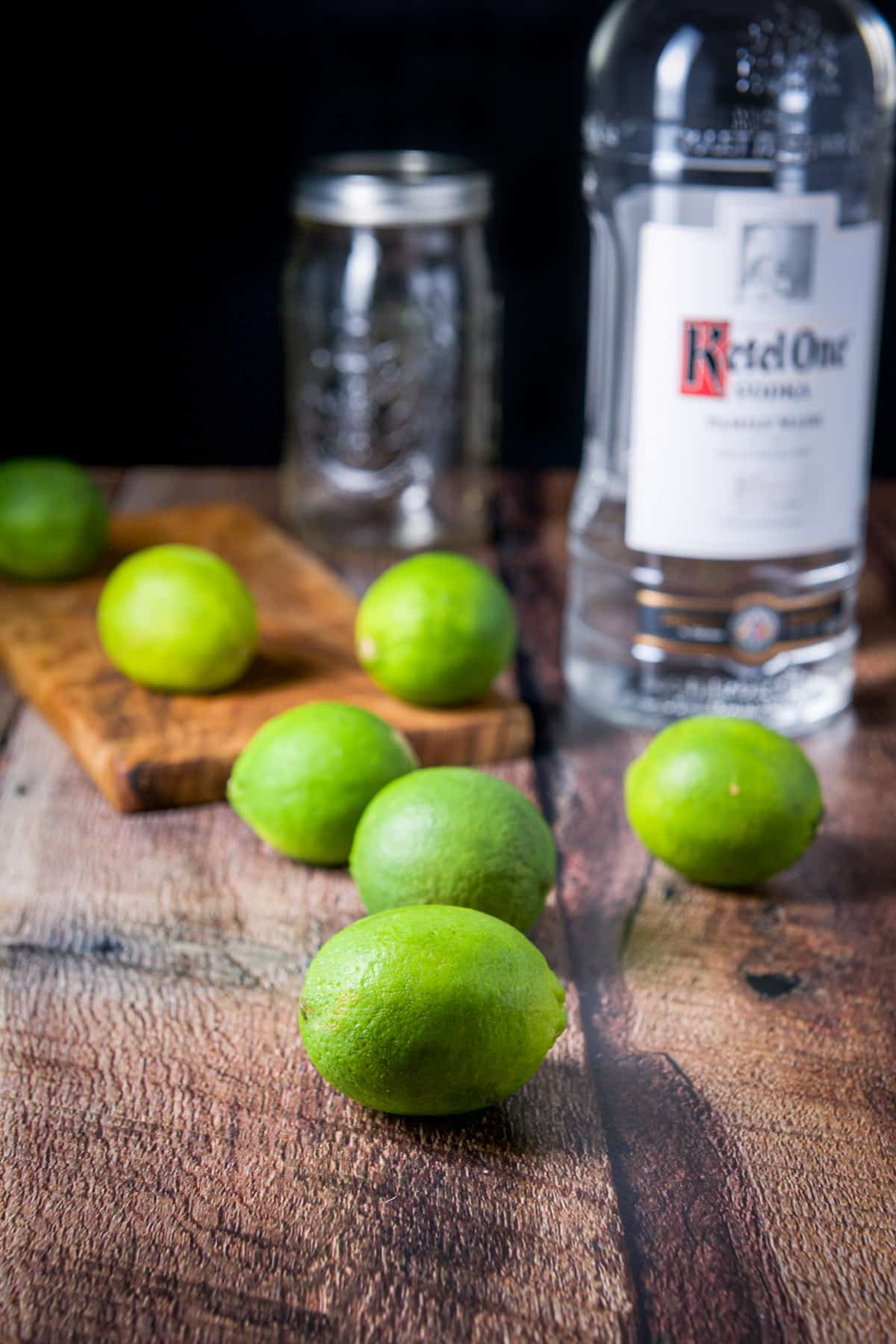 Limes on the table and vodka in a bottle