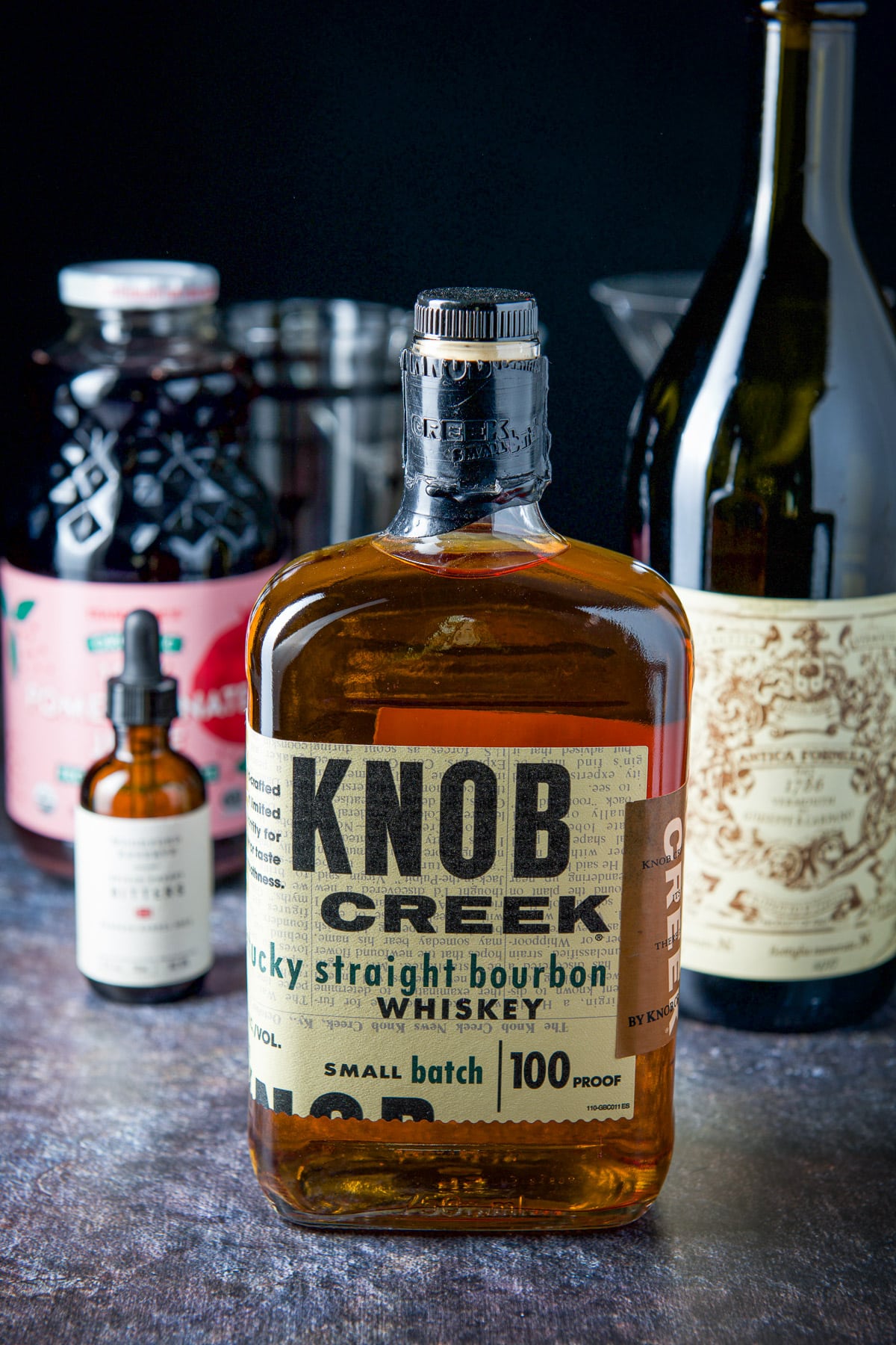 Bourbon, sweet vermouth, pomegranate juice and bitters on the table