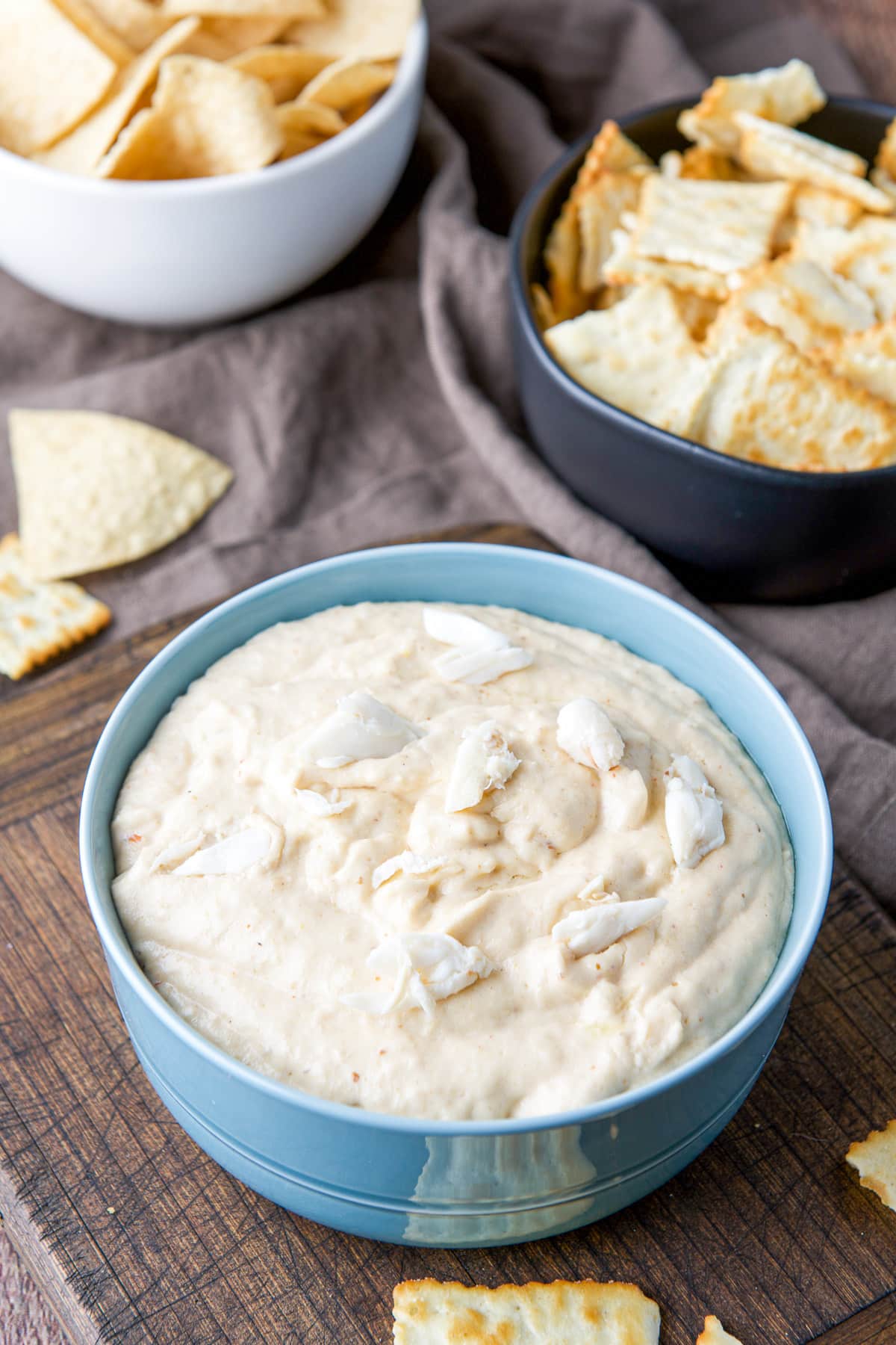 Lump crab on sprinkled on the dip with chips in other bowls