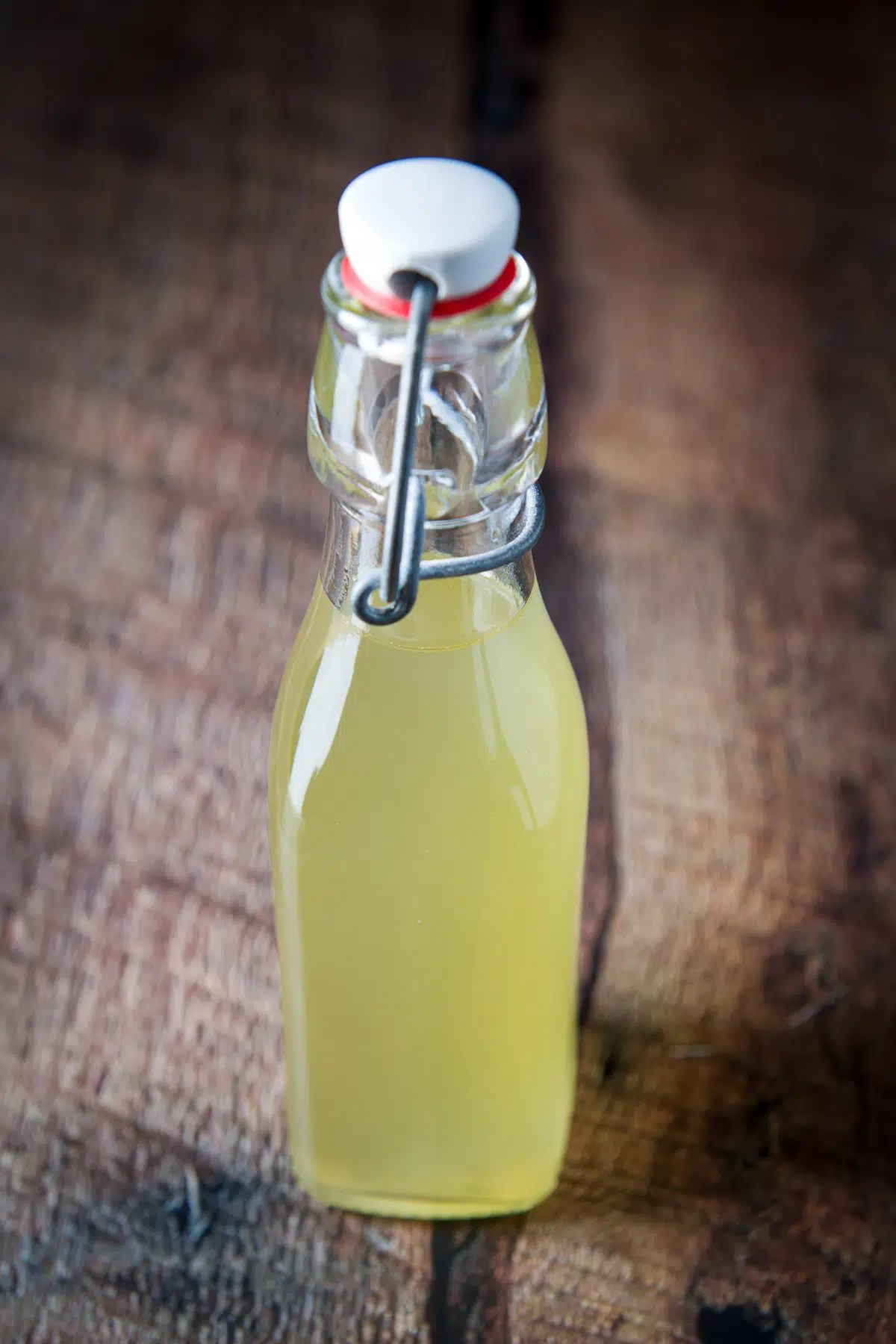 A bottle filled with a yellowish syrup