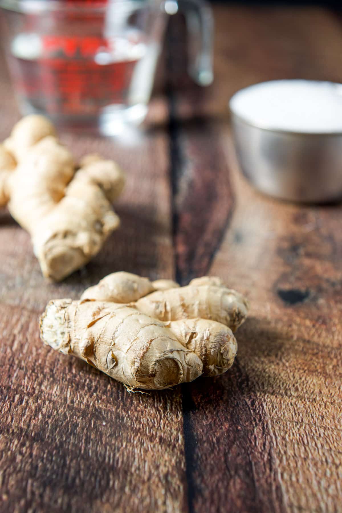 Ginger root, sugar and water on a wooden table