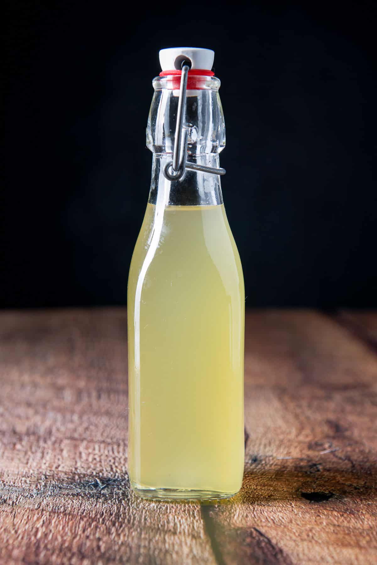 Vertical view of the syrup in the bottle on a wood table