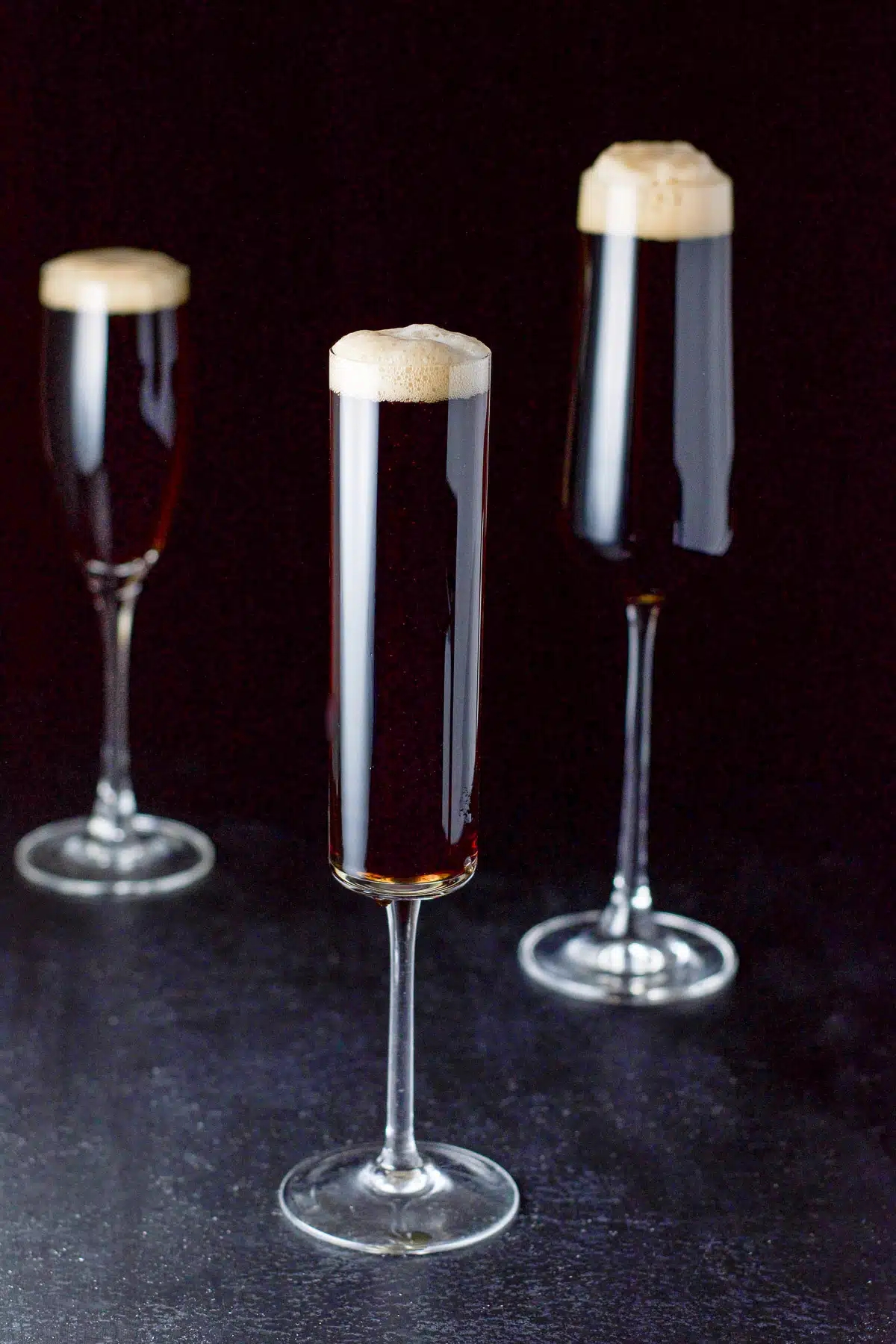 Three champagne glasses of the guinness cocktail