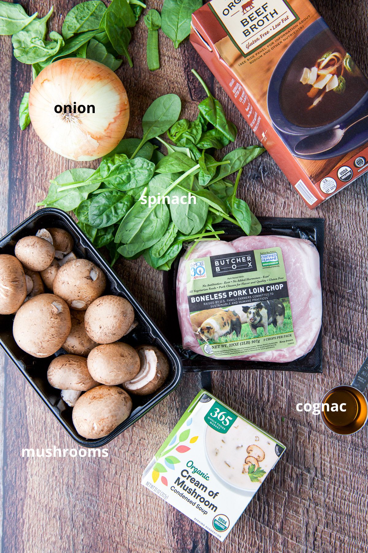 Pork chops, beef broth, onion, mushrooms, cognac and cream of mushroom soup on a table