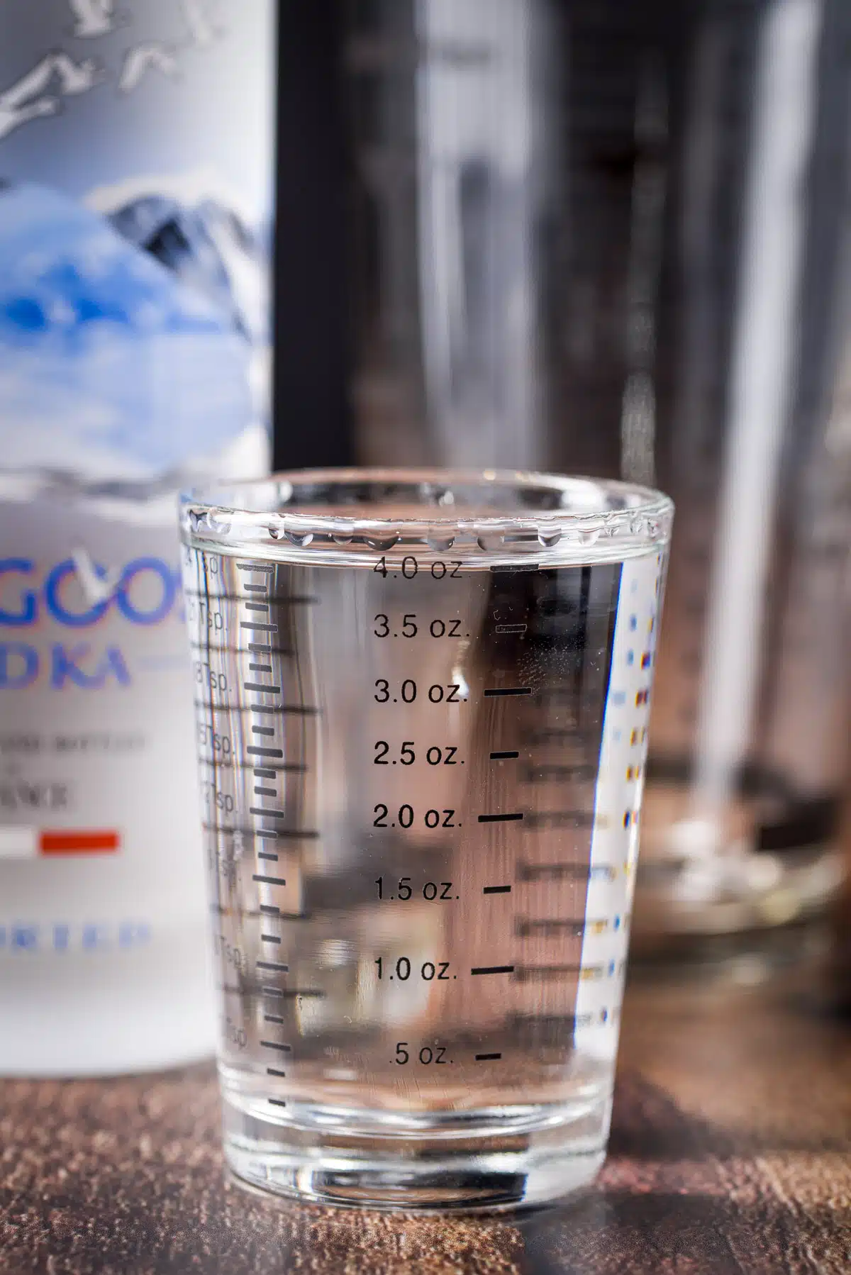 Vodka measured out with the bottle behind