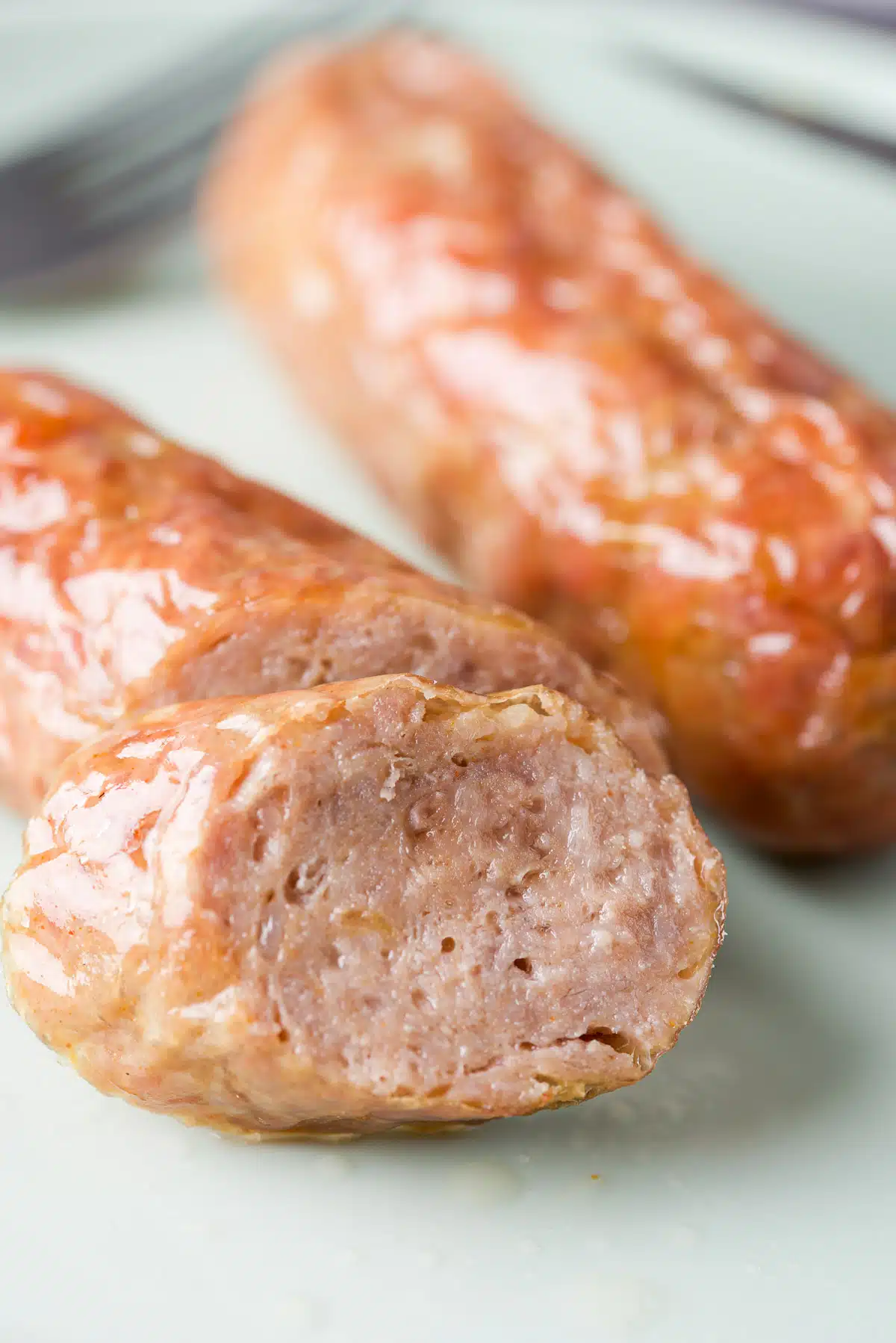 Close up of a slice of sausage on a plate with other sausages