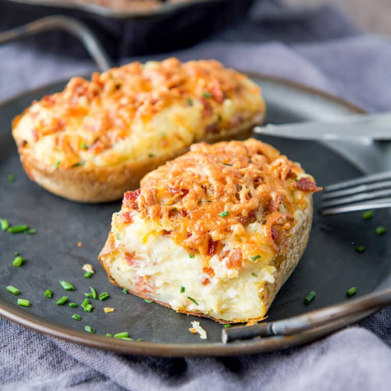 A metal platter with baked potatoes on it