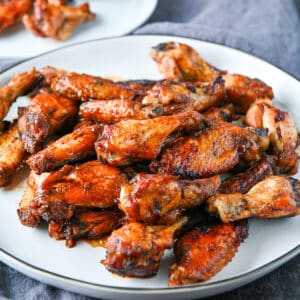 square photo of a white plate with chicken wings on it