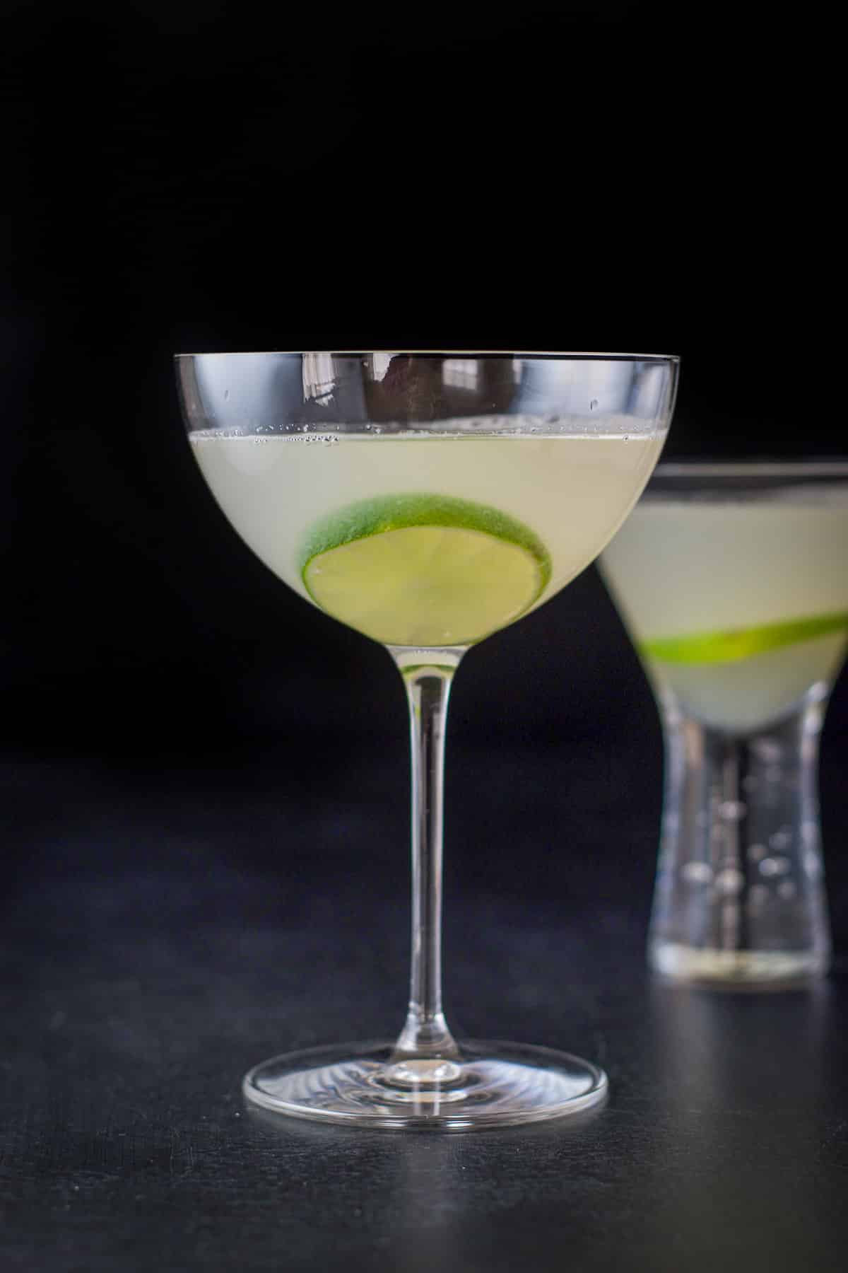 Vertical view of the lime cocktail in the two glasses with limes floating in them