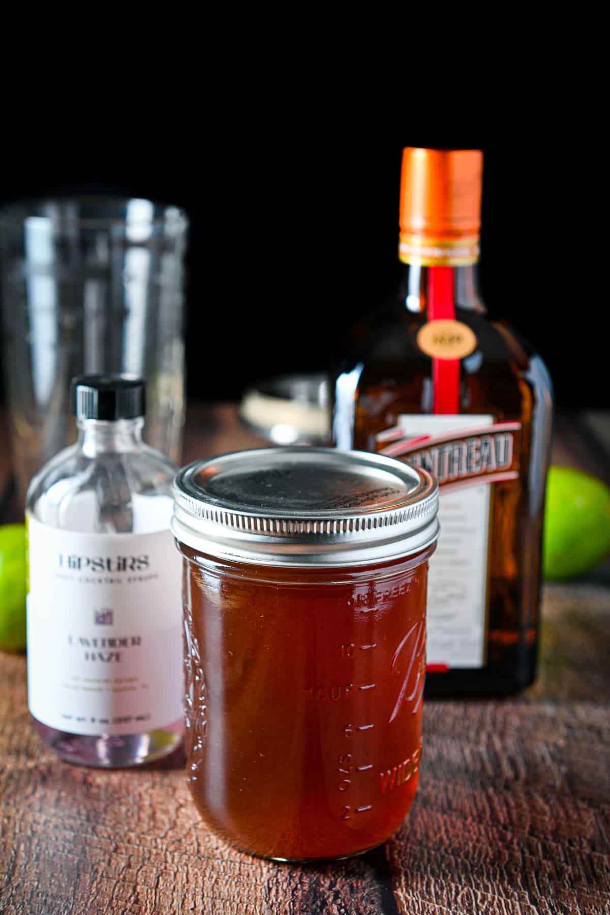 Blackberry vodka, cointreau, lavender syrup and limes on a table