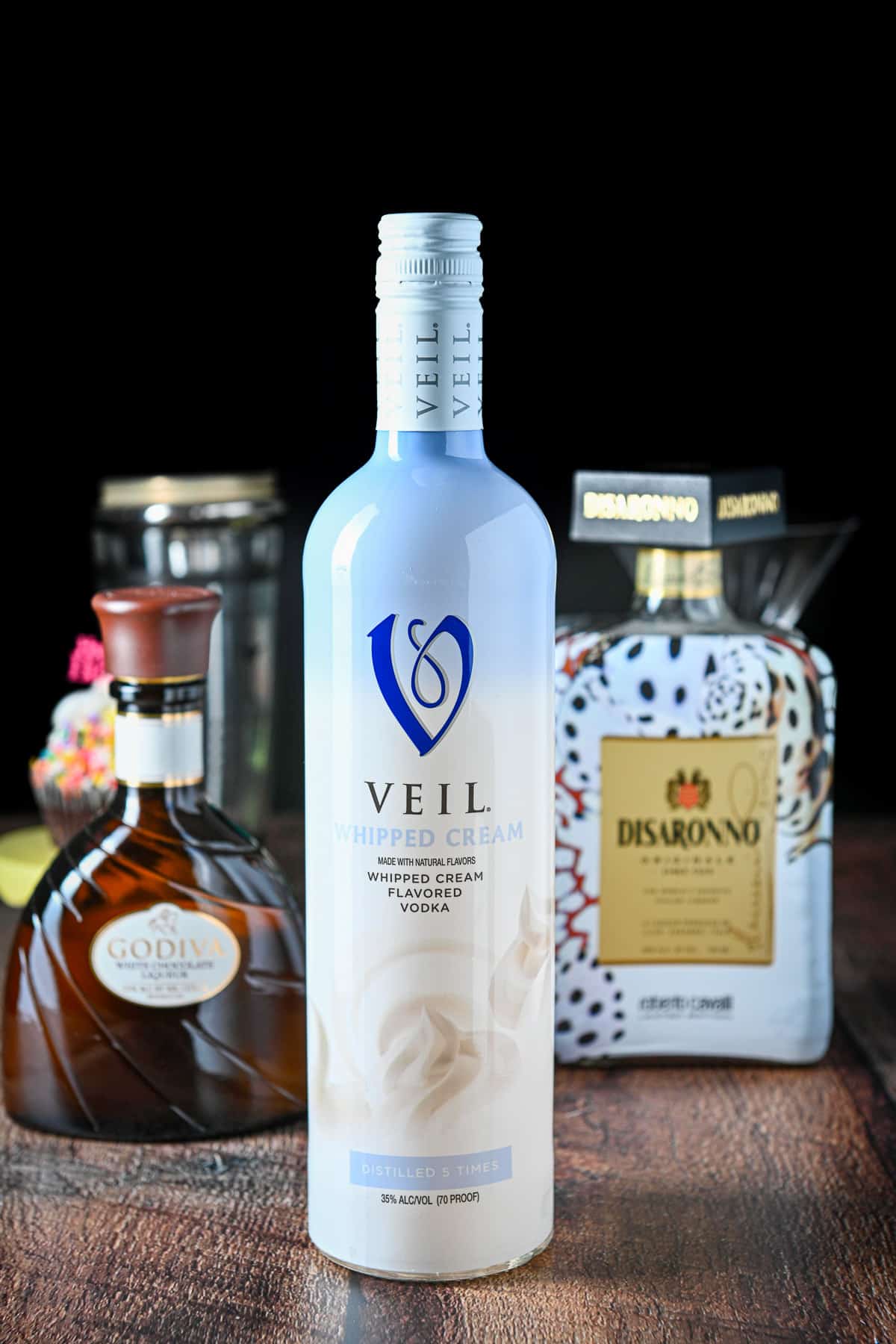 Bottles of whipped cream vodka, white chocolate liqueur, amaretto all on a table