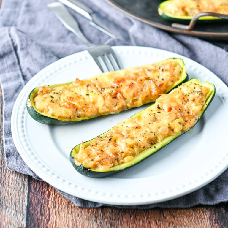 Square photo of two halves of a zucchini on a white plate