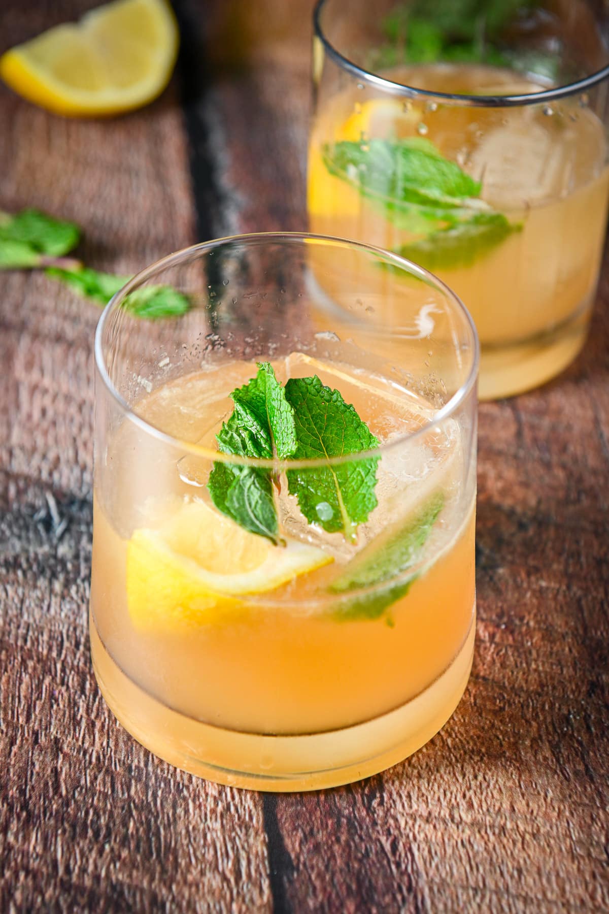 mint floating on the cocktail with whiskey and lemon