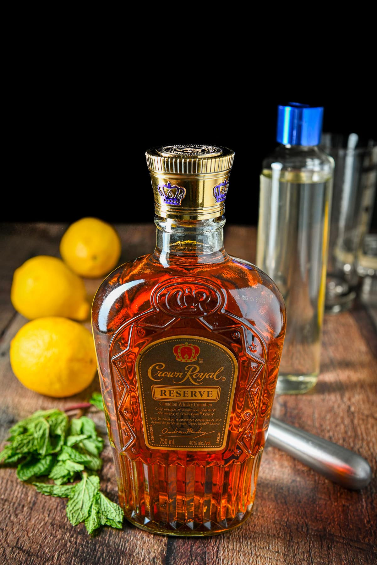 Whiskey, mint, lemon, and simple syrup on a table