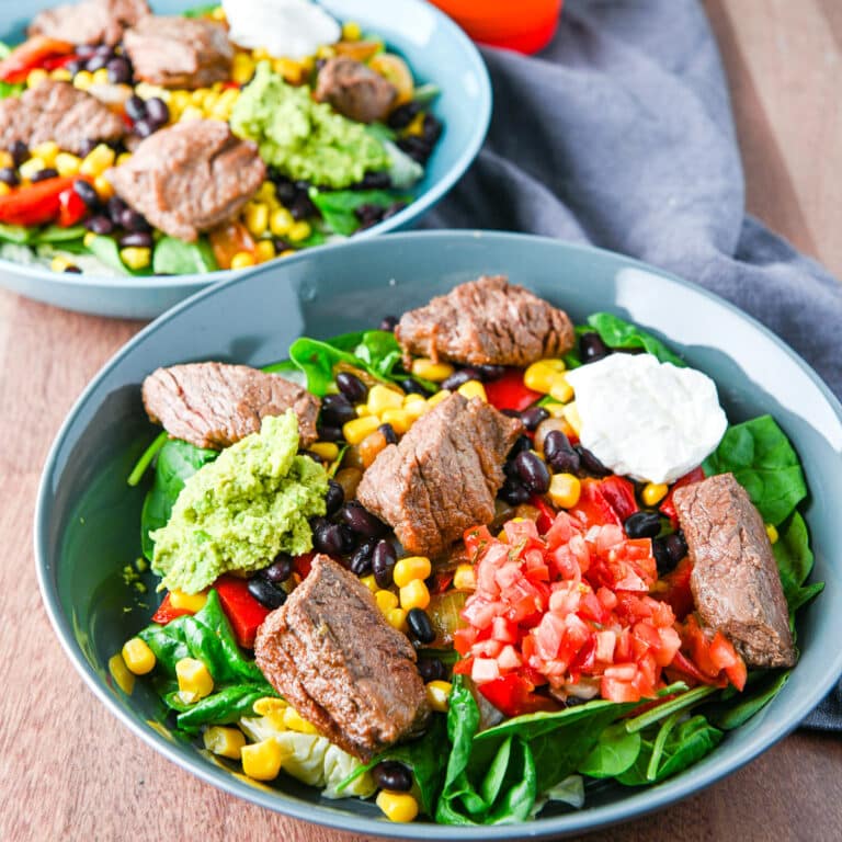 Two bowls with the fajita on lettuce and condiments