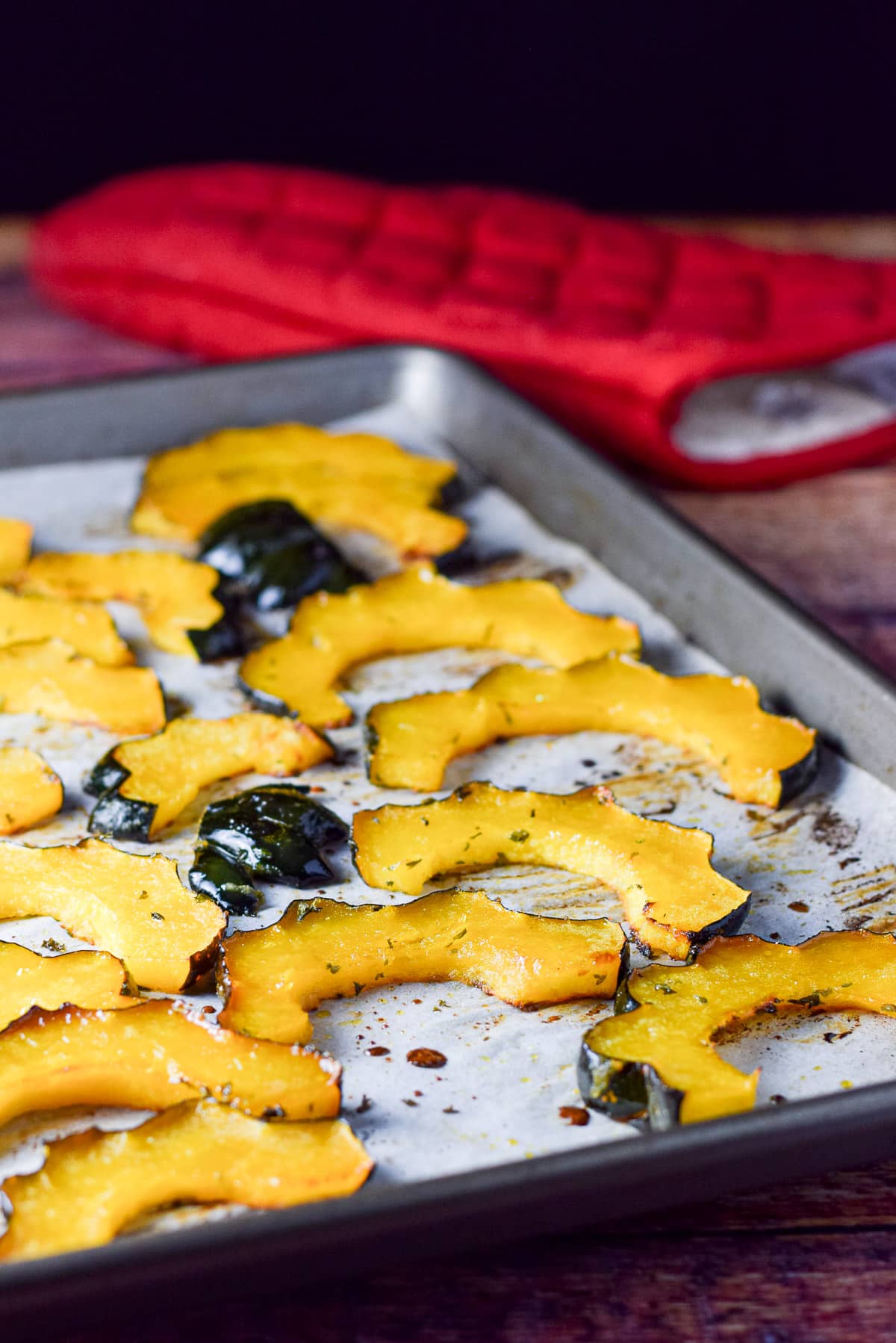 Slices of acorn squash fresh out of the oven on a pan and ready for consumption